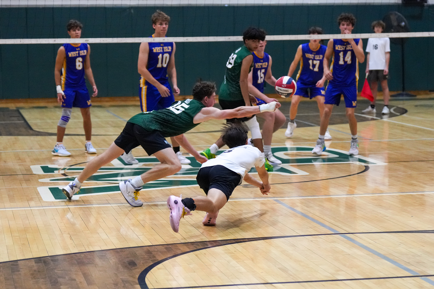 Senior outside hitter Will Jankowski and junior liber Aaron Kiefer dive for the ball. RON ESPOSITO