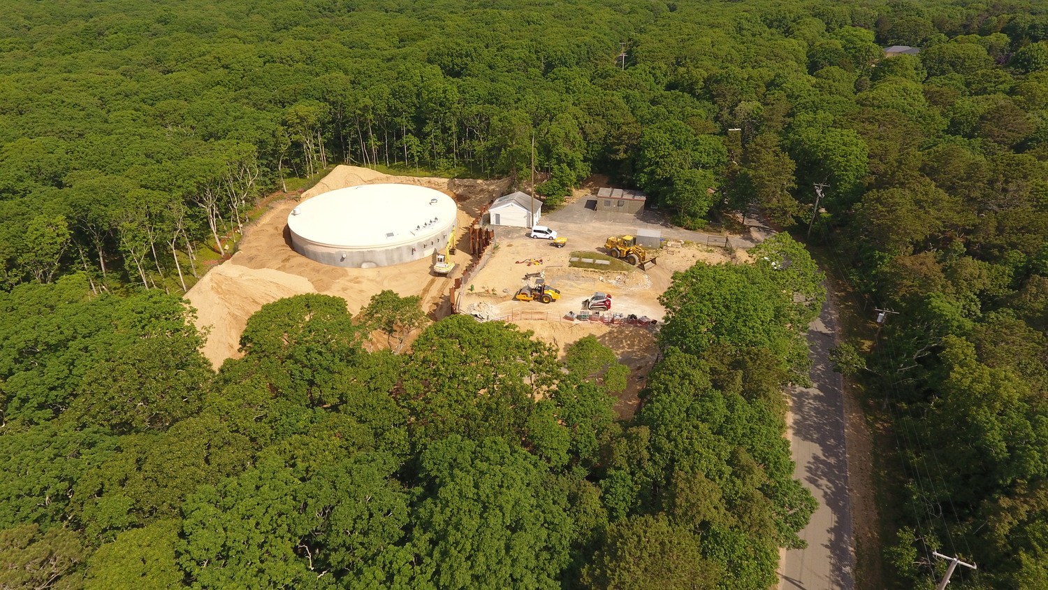 A 900,000 gallon water storage tank under construction in Amagansett in 2020. The tank was built to address weak water pressure in Amagansett and Montauk because of increasing demands on the pumping system that threatened the ability of fire hydrants to deliver sufficient water pressure for firefighters hoses. The 100-foot-wide, 20-foot-tall tank cost more than $3 million to build, a cost shared by all SCWA rate payers, even though the main catalyst for the tank's necessity was sprinkler and heating systems at Hamptons' estates. 
MICHAEL WRIGHT