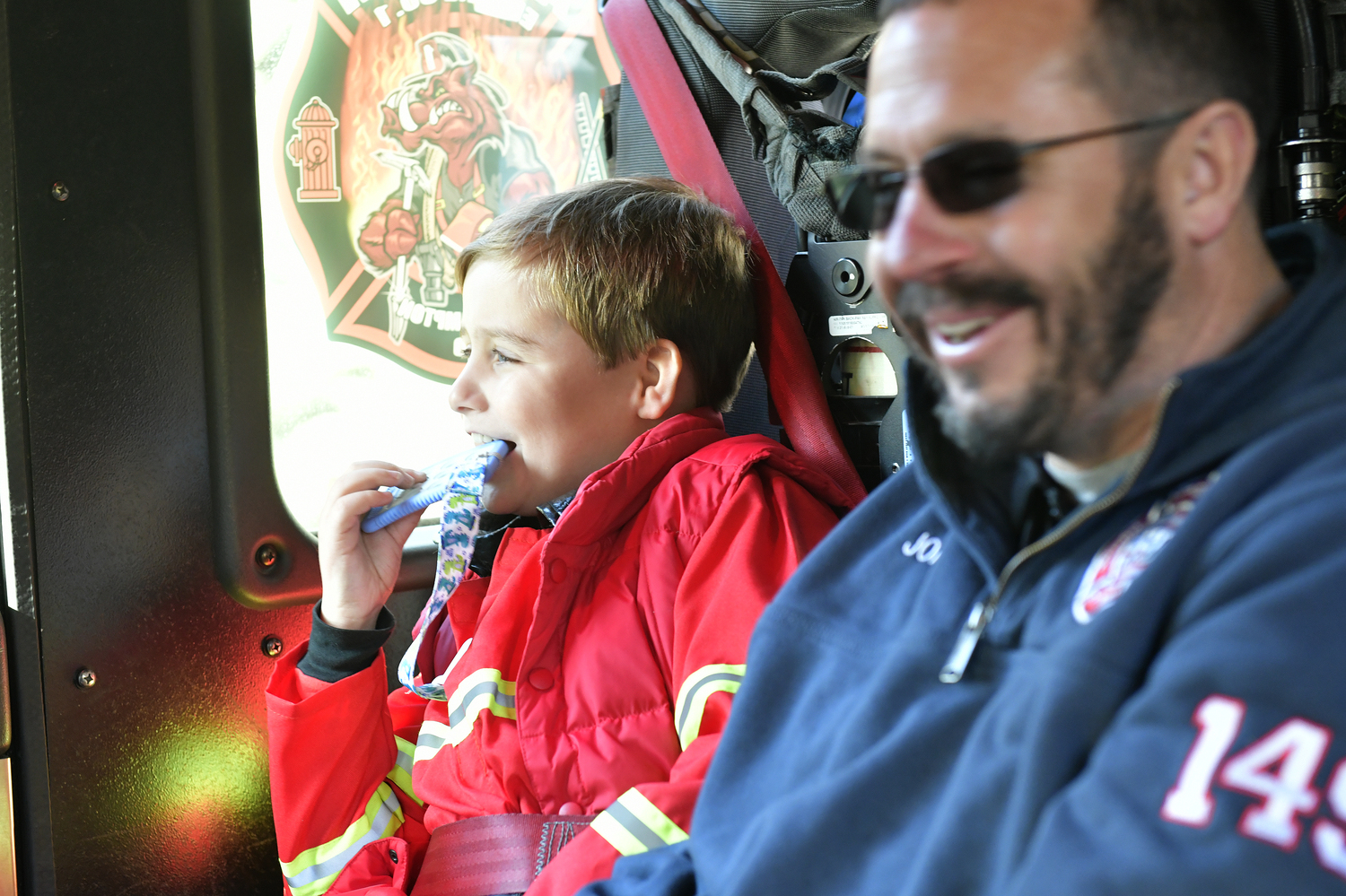 Rowland Egerton-Warburton, with Southampton Agawam Engine firefighter John Parry, getting a ride a fire truck for his birthday on November 15.         DANA SHAW