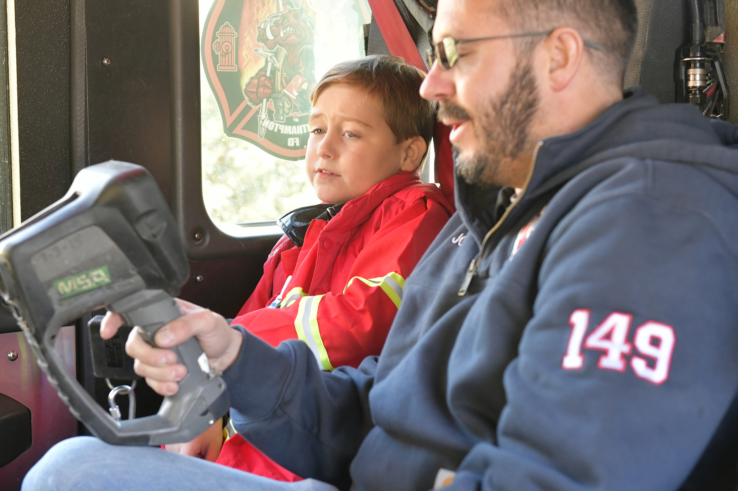 Rowland Egerton-Warburton, with Southampton Agawam Engine firefighter John Parry, getting a ride a fire truck for his birthday on November 15.         DANA SHAW