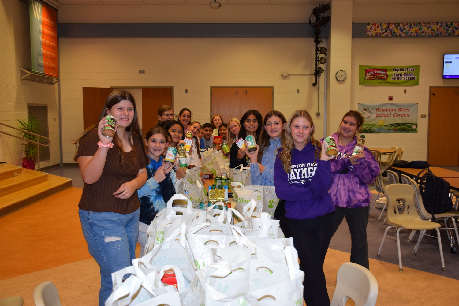 Members of the Hampton Bays Middle School OWL Club and Tri-M Music Honor Society recently volunteered their time to pack food donations as part of a partnership with Heart of the Hamptons. All of the packages will be donated to families in need within the school district. COURTESY HAMPTON BAYS SCHOOL DISTRICT