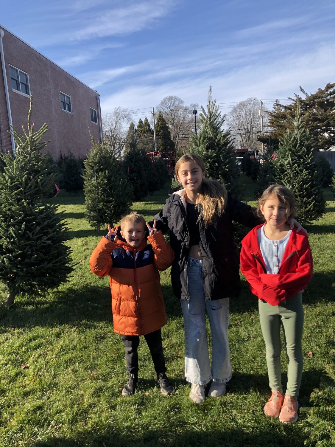 From left, Sebastian, Kendall and Claire Riley at the Christmas tree sale at the East Quogue Fire Department during the inaugural 