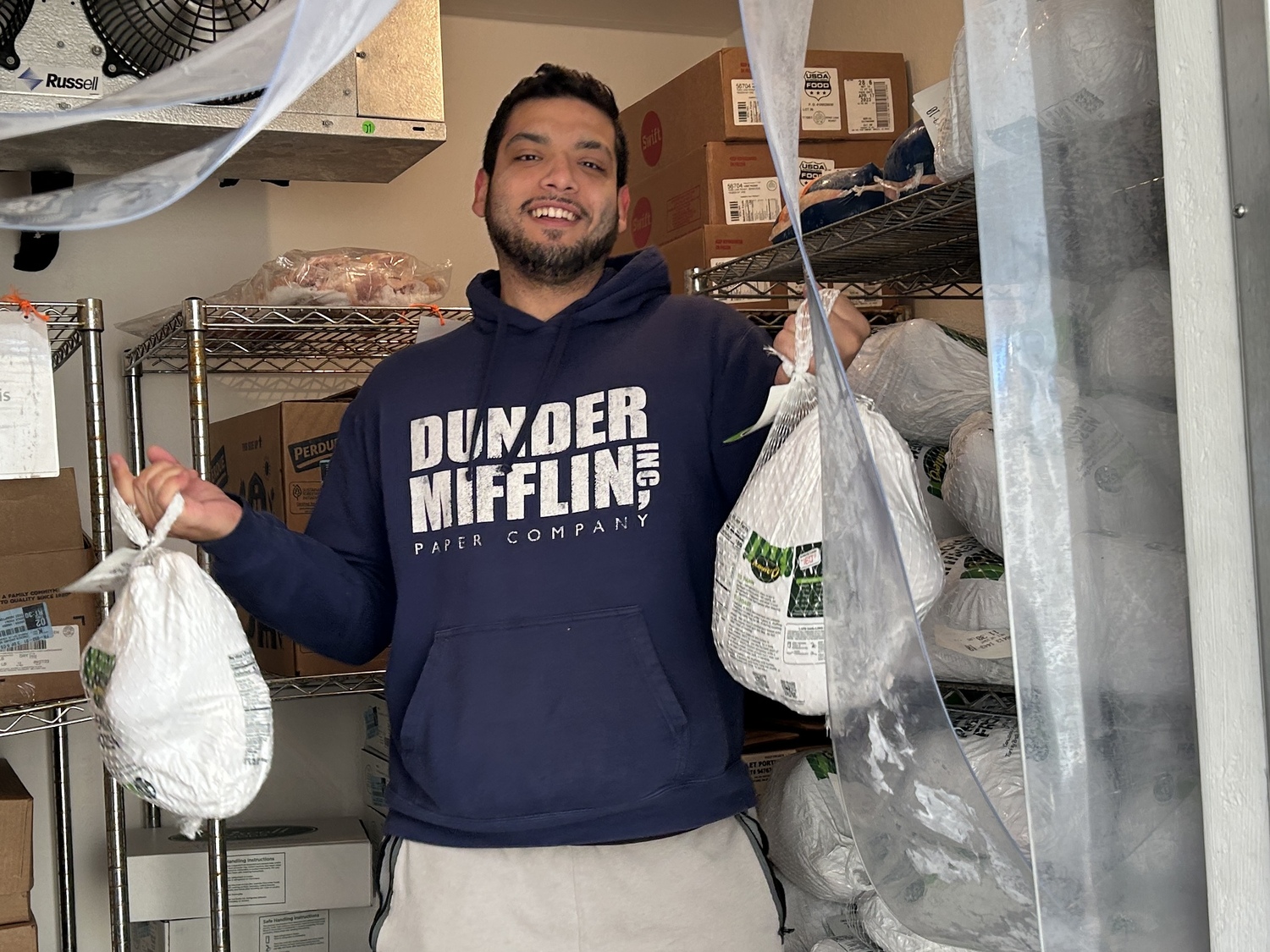 Brandon Levy in the freezer hoisting turkeys. The pantry received its first shipment of turkeys last week.   COURTESY EAST HAMPTON FOOD PANTRY