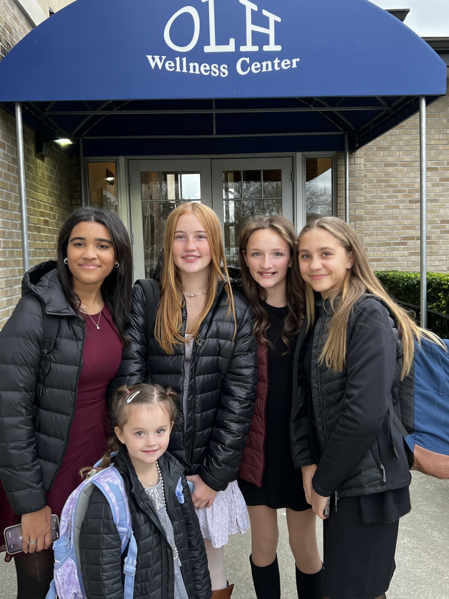 Our Lady of the Hamptons School Prep 8 students Aliah Donohoe, Estee Phair, Olivia Robertson and Grace Gonzalez escorted kindergartener Macie Jo Phair to the school's recent Thanksgiving Feast. COURTESY OUR LADY OF THE HAMPTONS SCHOOL