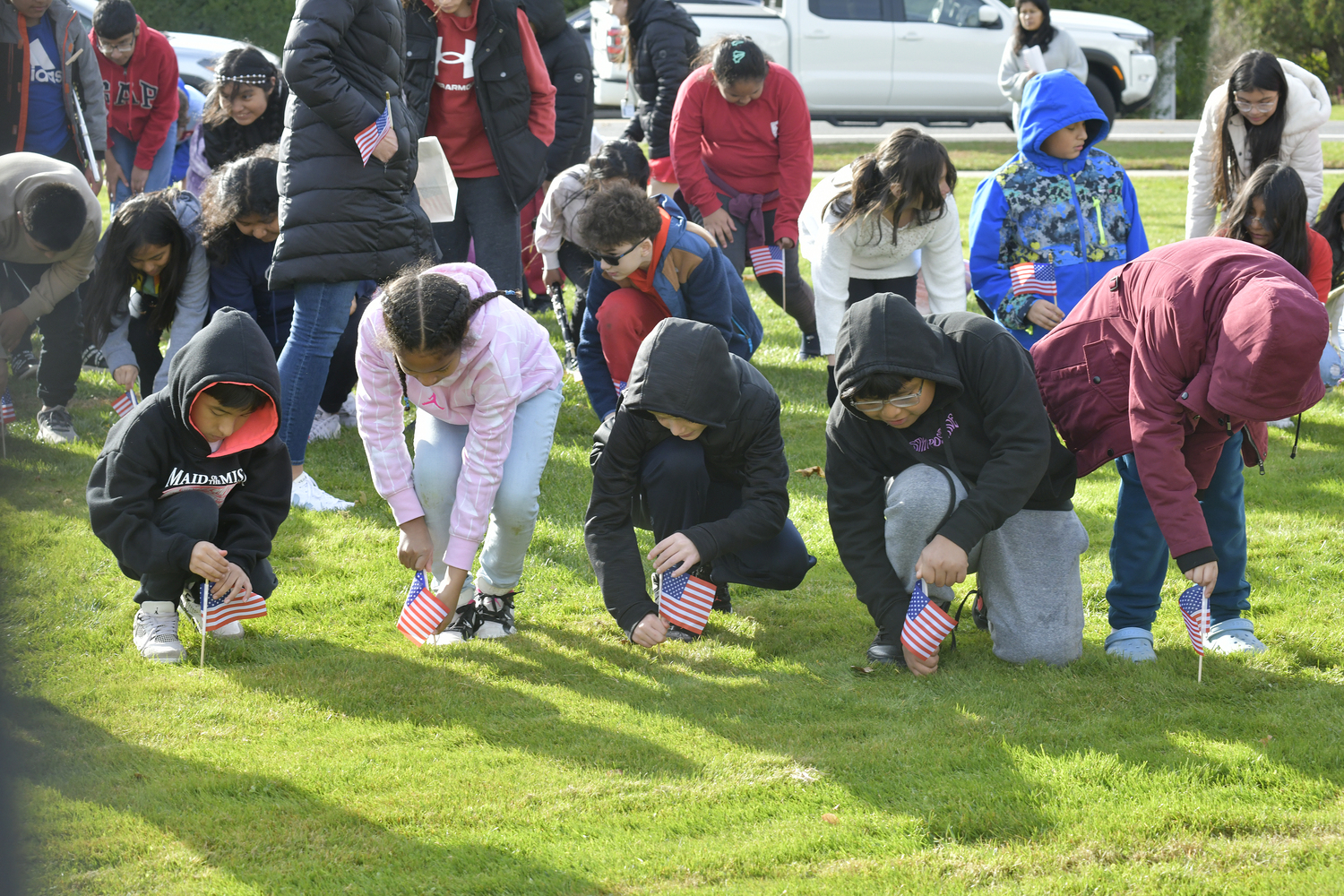 Students and faculty Tuckahoe School hosted its first ever Field of Flags event honoring veterans on November 8. students place flags on the lawn in front of the school.  DANA SHAW