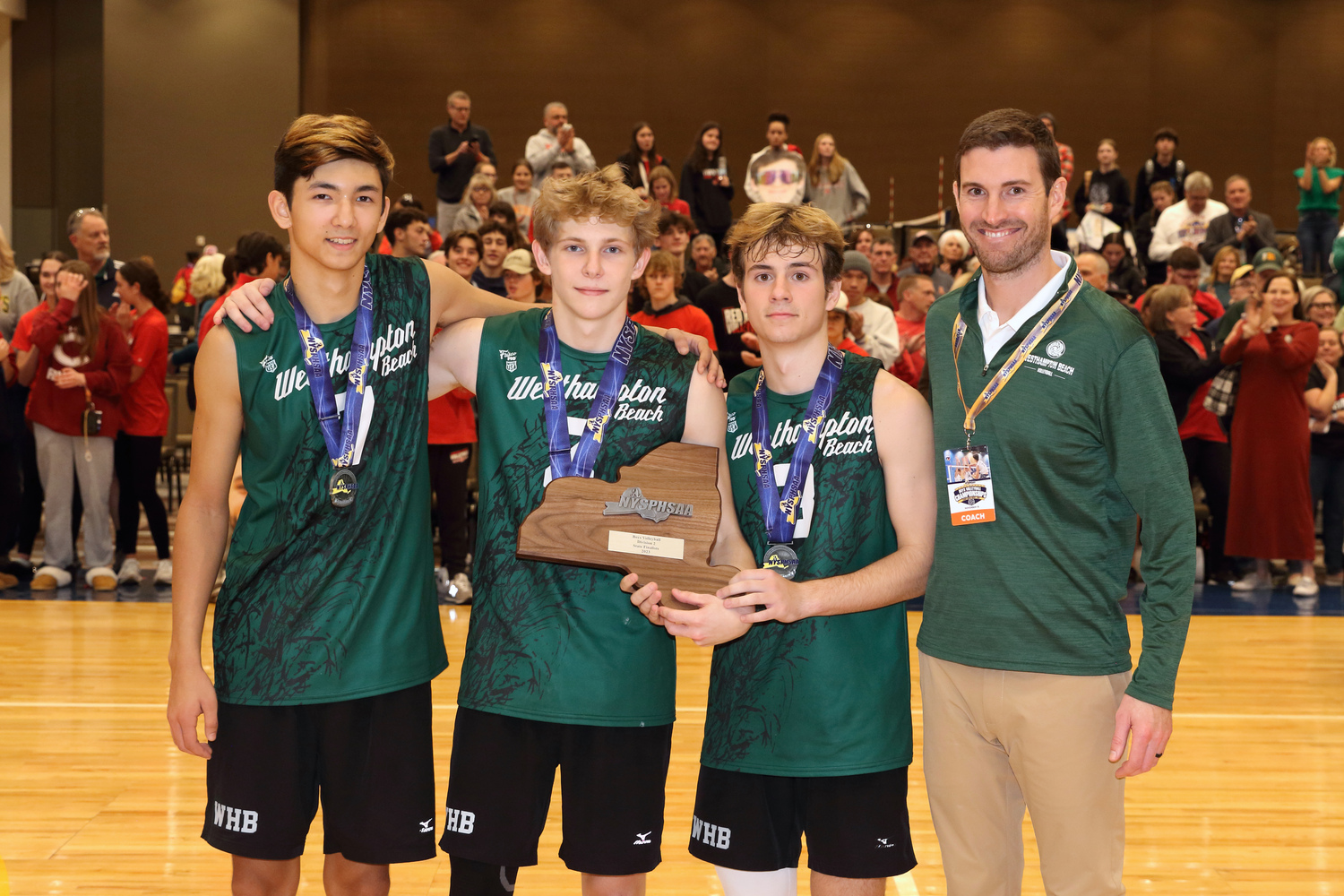 Westhampton Beach seniors Alec Kelly, Casey Sidor and Seth Terry with head coach Josh Tuttle and their state championship runner-up plaque. MARK DEBORTOLI