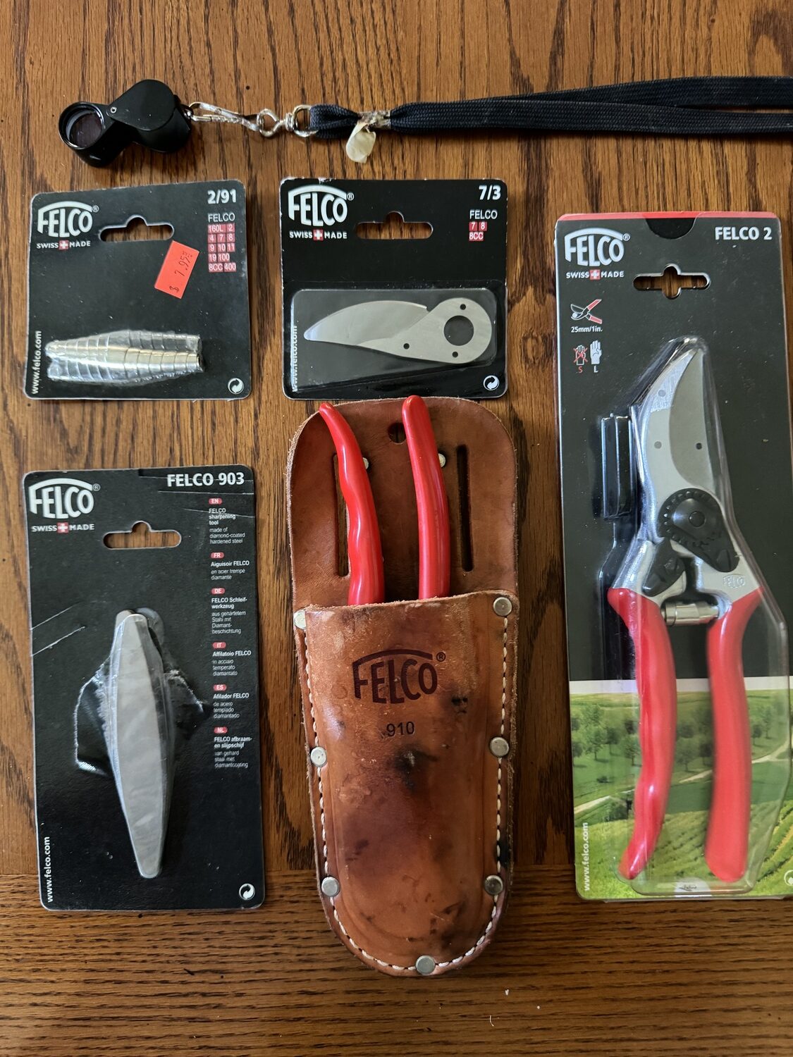 The classic and sturdy Felco #2 (right). Then to the left is the #910 holster that attaches to a belt. Also pictured are the accessories to keep the #2 in great shape from a sharpening stone to a spring and replacement blade. The entire 
