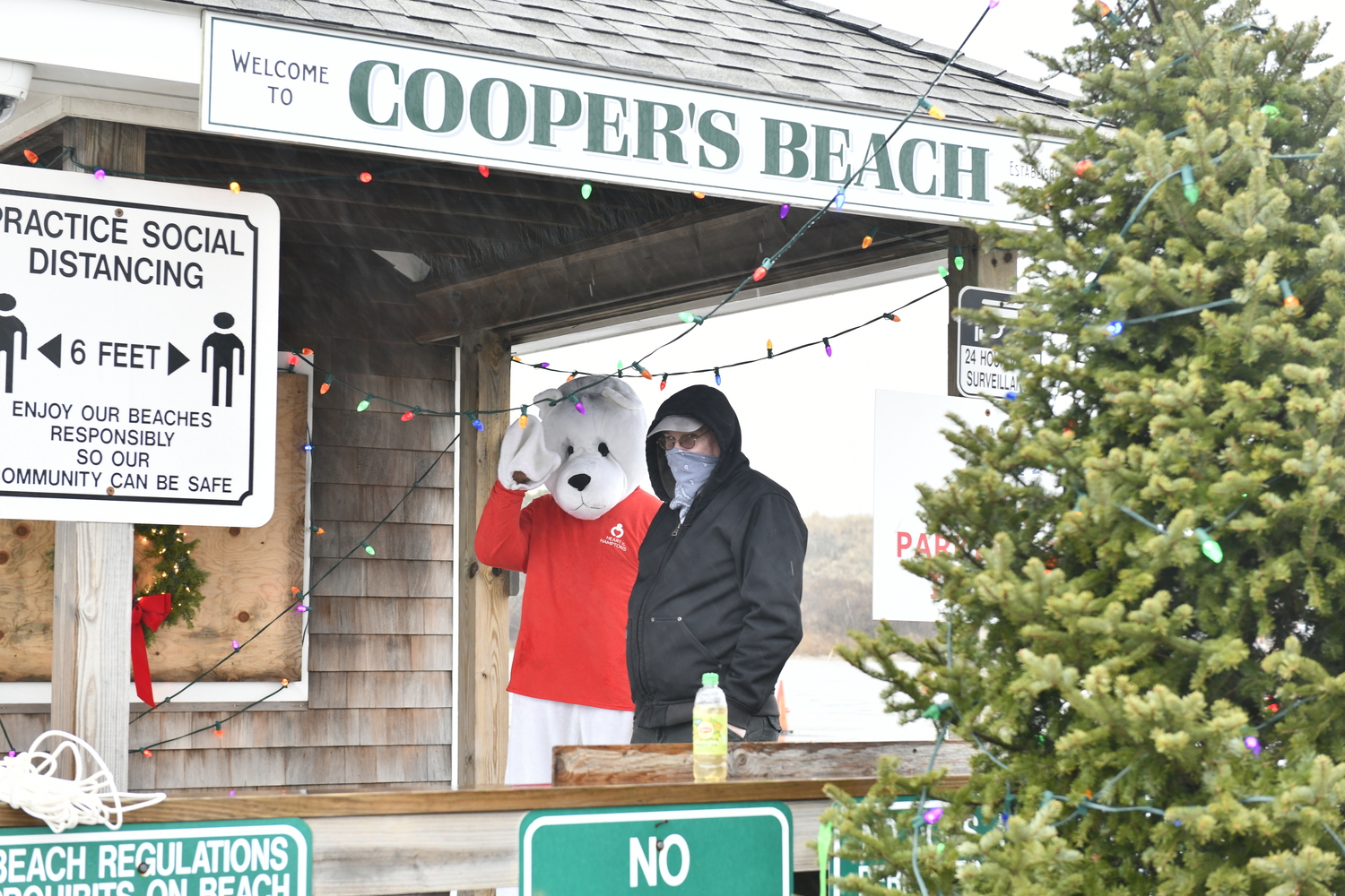 Due to COVID restrictions in 2020, the Polar Bear Plunge was held as a Parade down Main Street to Coopers Beach. A few people ventured into the water with masks.  DANA SHAW