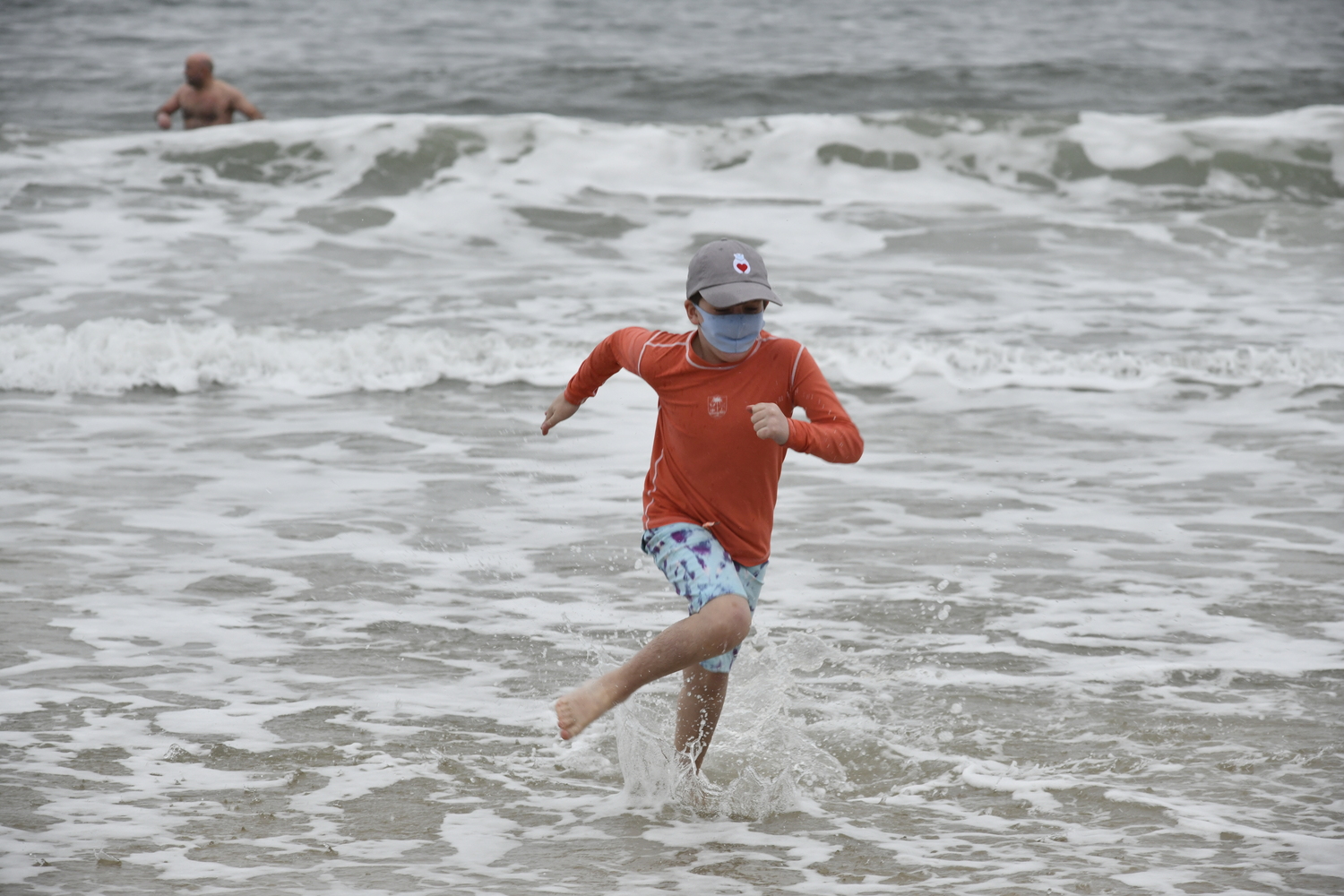 Due to COVID restrictions in 2020, the Polar Bear Plunge was held as a Parade down Main Street to Coopers Beach. A few people ventured into the water with masks.  DANA SHAW