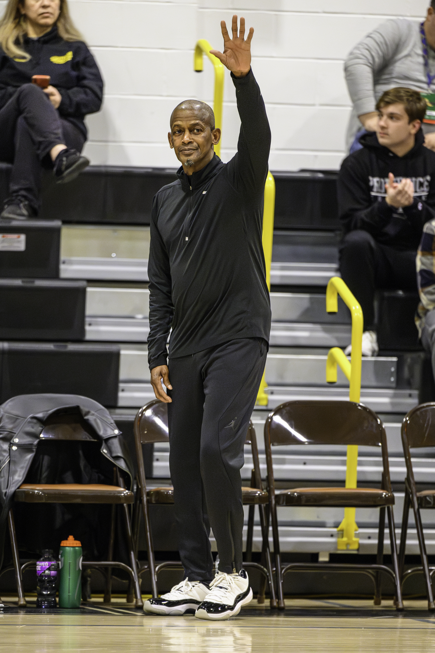 Carl Johnson waves to the crowd after he is reintroduced as head coach of the Bridgehampton boys basketball at their first home game on Thursday, December 14.   MARIANNE BARNETT
