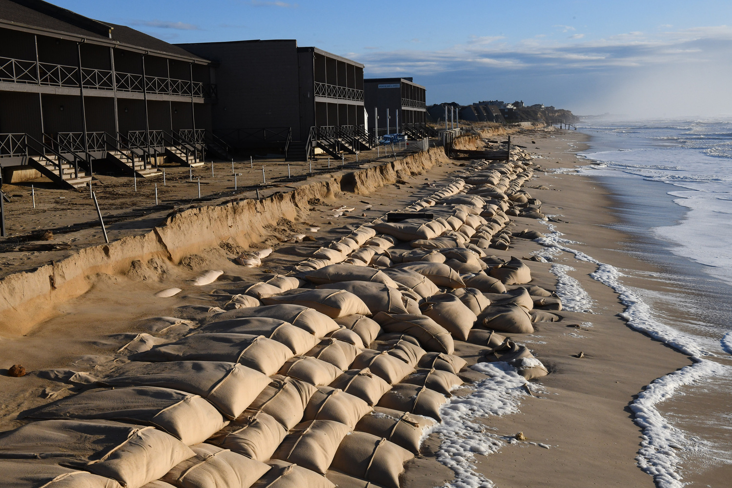 The sand bag revetment along downtown Montauk was battered by Monday's storm, which hit at high tide with tropical storm force winds and waves over 25 feet high. DOUG KUNTZ