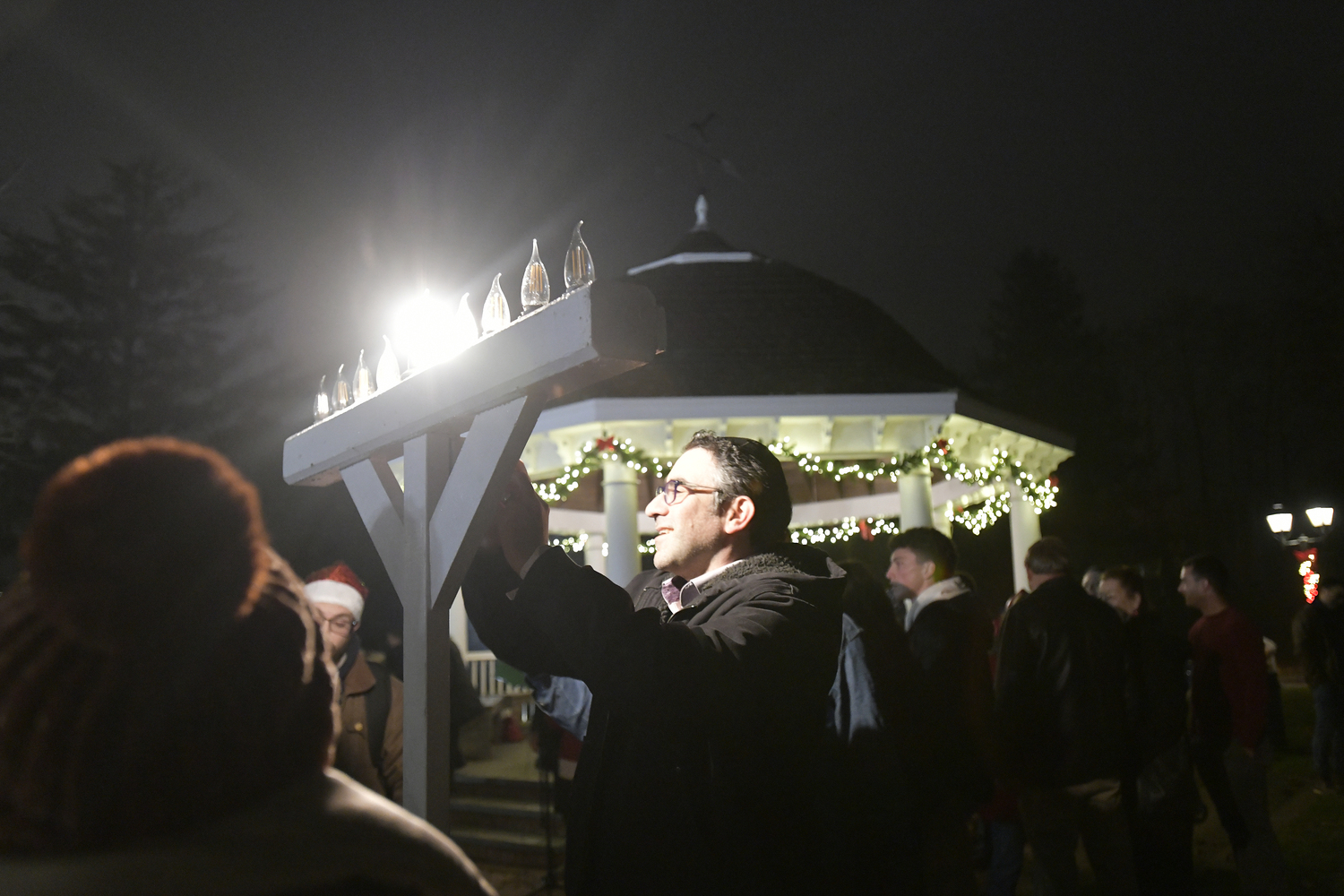 Rabbi Avraham Bronstein of The Hampton Synagogue lights the menorah on the village green.