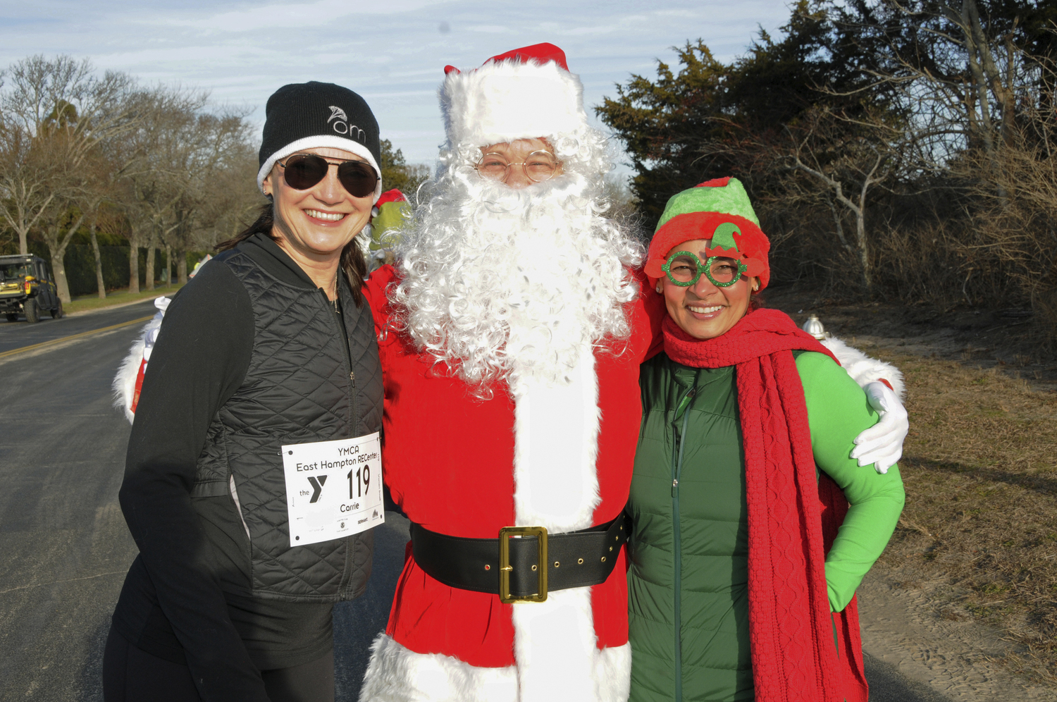 Carrie Rebora Barratt, Santa Dan Jacobs and Elf Oneikka Jacob at the 5K run on Saturday to support programs and camp at the YMCA East Hampton RECenter. The top three winners of a Y Gift Basket and one-year YMCA membership, in order, were Justin Kulchinsky, Nick DeLuca and Matthew Zappoli.    RICHARD LEWIN