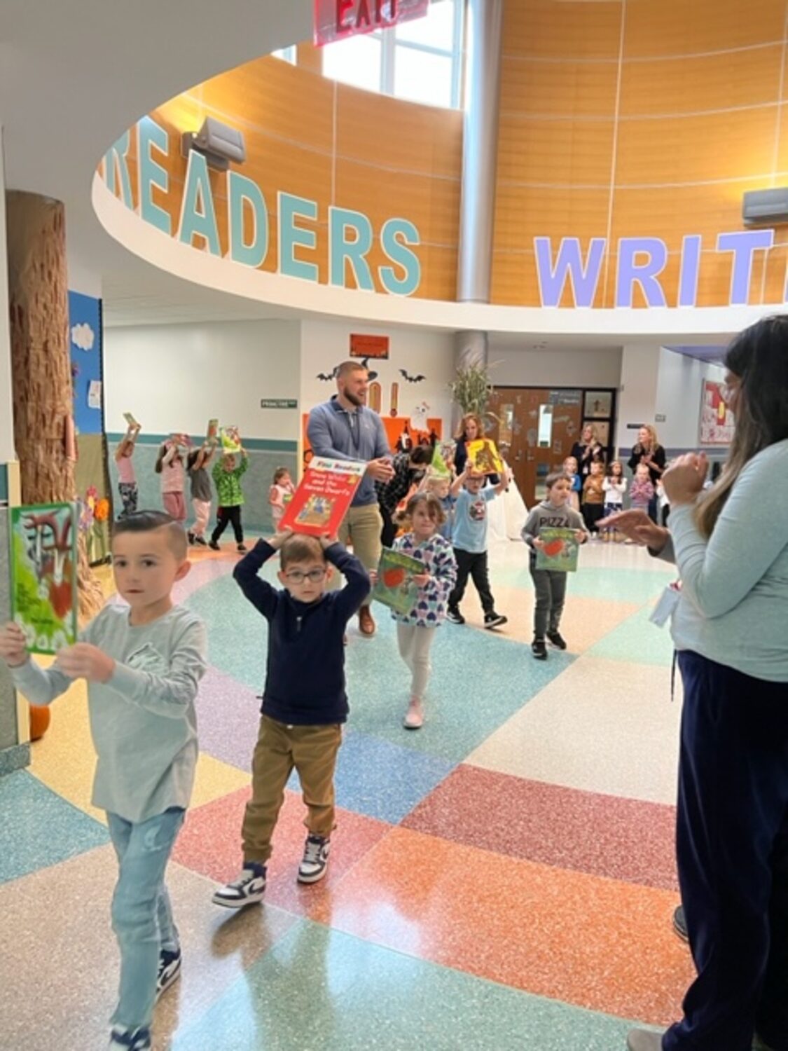 Tuttle Avenue Elementary School kindergarten students held their favorite books over their heads as they paraded through the school rotunda celebrating the end of the semester’s reading and writing units. COURTESY EASTPORT-SOUTH MANOR SCHOOL DISTRICT