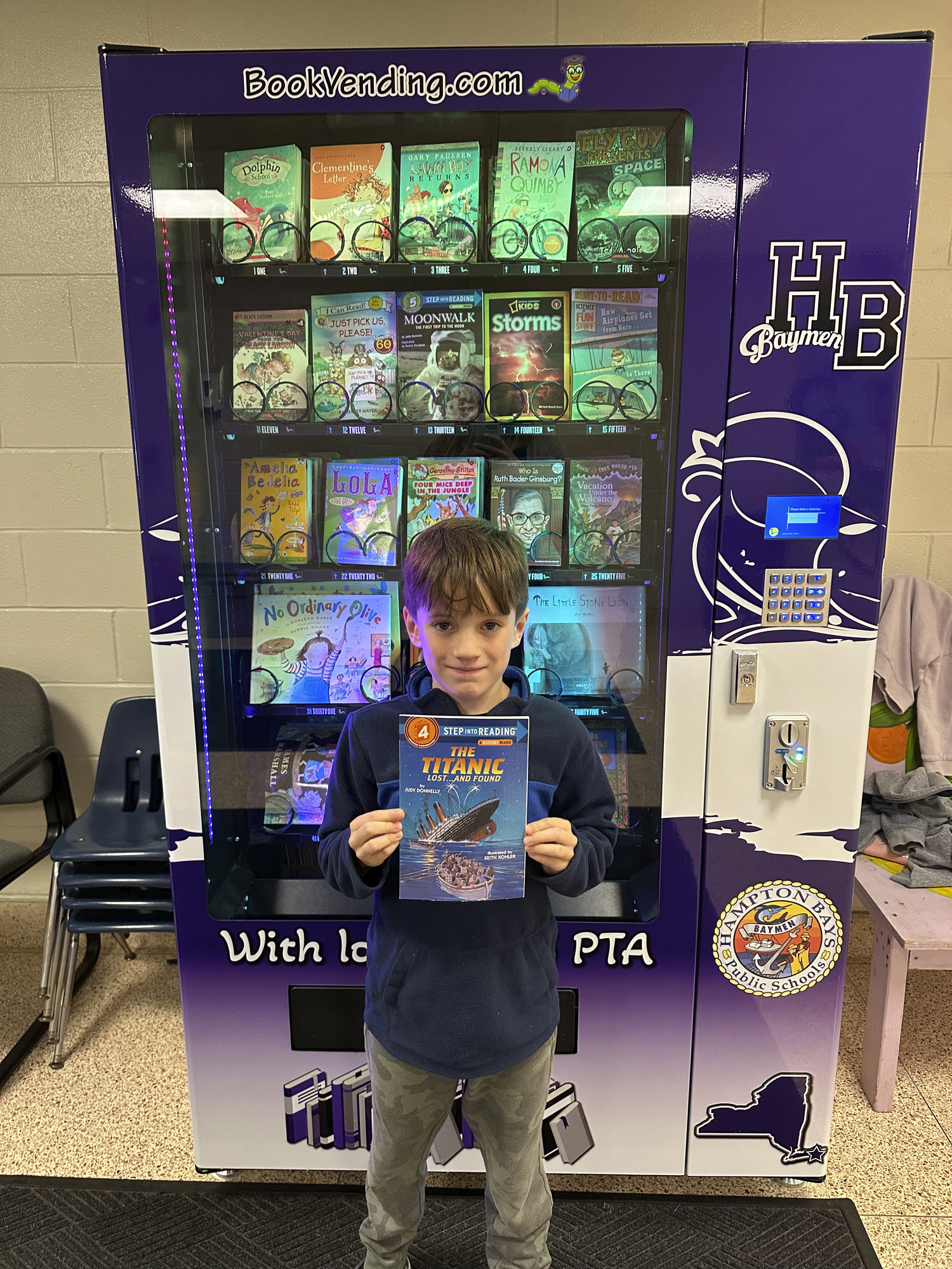 Lincoln Hatton was among the first to try a new book vending machine program at Hampton Bays Elementary School, a gift of the Hampton Bays PTA. The machine dispenses books to students who display traits, including kindness, generosity, fairness, perseverance, honesty, tolerance, gratitude, courage and responsibility, taught through the school’s character education program. Each month, a student from each classroom is selected by the school’s principals as vending machine token winners. Students use their earned token to select a book from the vending machine. COURTESY HAMPTON BAYS SCHOOL DISTRICT