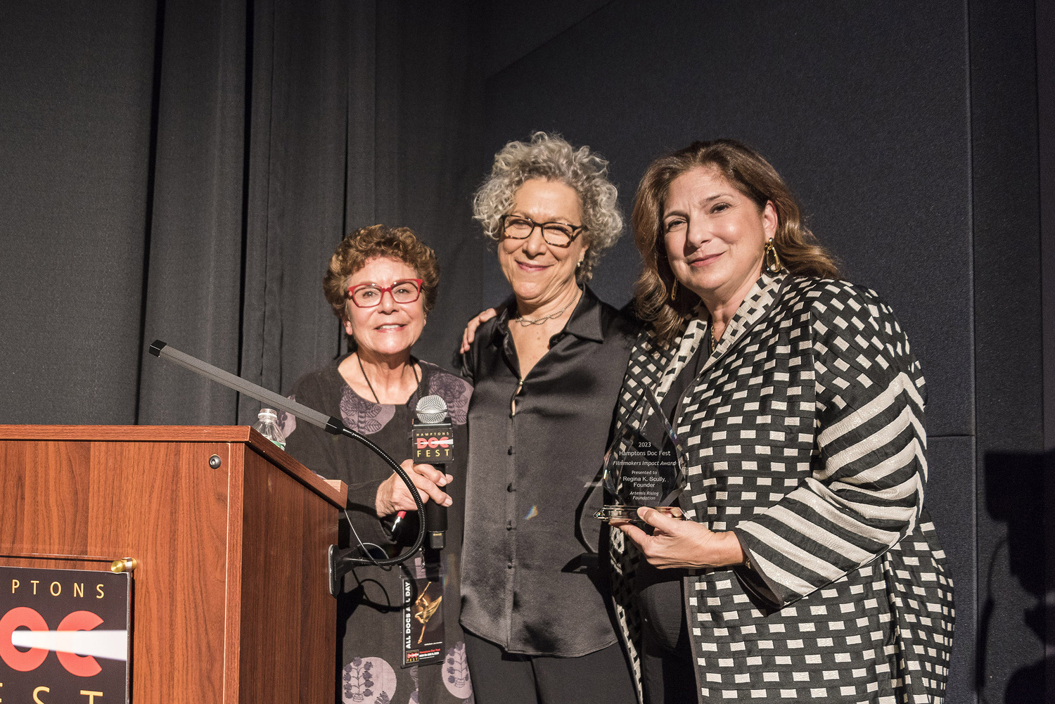 HDF executive director Jacqui Lofaro and HDF Advisory Board member Susan Margolin, a producer of the film, presented the HDF 2023 Impact Award to Regina K. Scully, founder of the Artemis Rising Foundation, which has supported hundreds of films including “Obsessed with Light,” co-presented with NY Women in Film & Television (NYWIFT) at Sag Harbor Cinema on December 1. COURTESY HAMPTONS DOC FEST