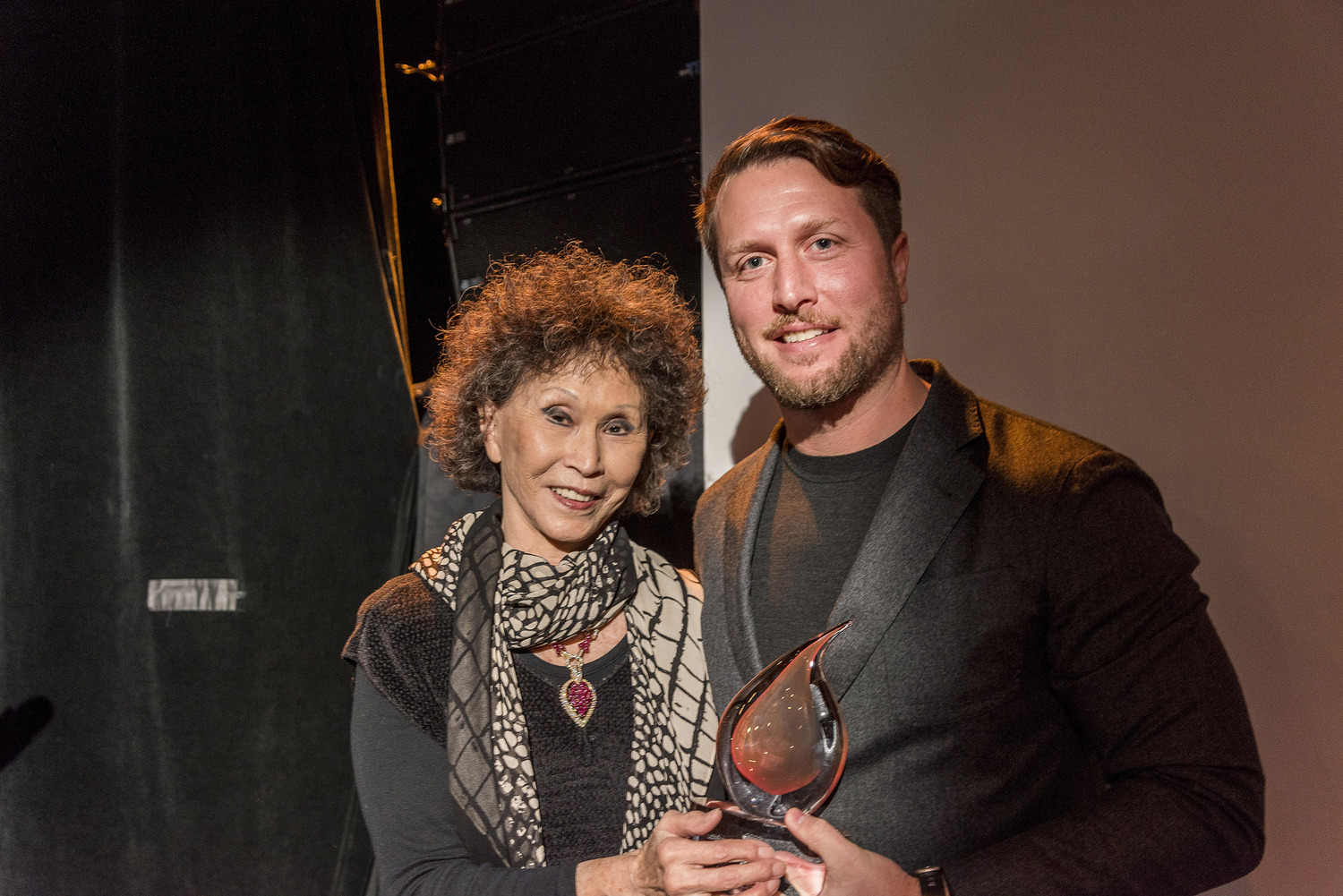 Matthew Heineman, director of “American Symphony,” shown at the December 2 Hamptons Doc Fest Gala at Bay Street Theater, receives the HDF 2023 Pennebaker Career Achievement Award from filmmaker Lana Jokel, who sponsors the annual award. COURTESY HAMPTONS DOC FEST