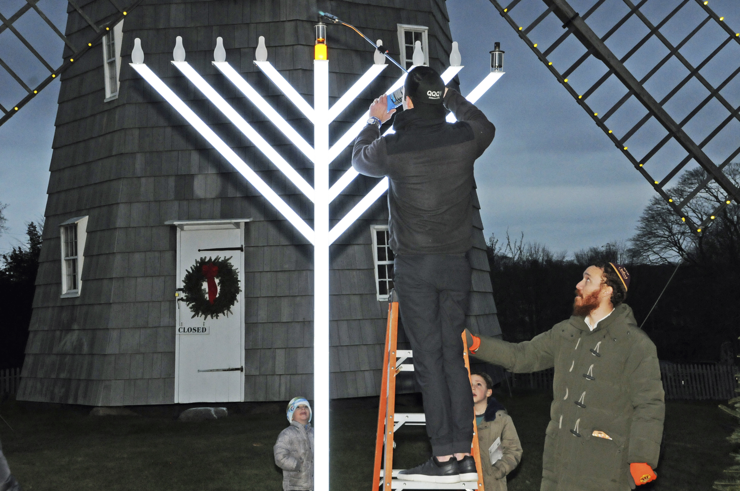 Matt Bielski and Rabbi Aizik Baumgarten light the Menorah on Thursday afternoon. Chabad of the Hamptons hosted the start of Hanukkah at Hook Mill in East Hampton.    RICHARD LEWIN