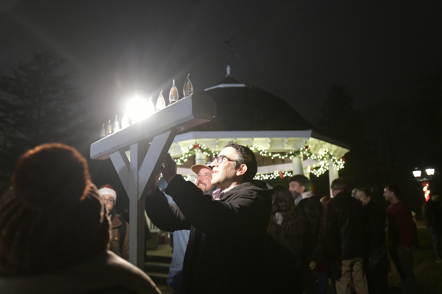 Rabbi Avraham Bronstein of The Hampton Synagogue lights the menorah on the village green in Westhampton Beach on December 2.  DANA SHAW