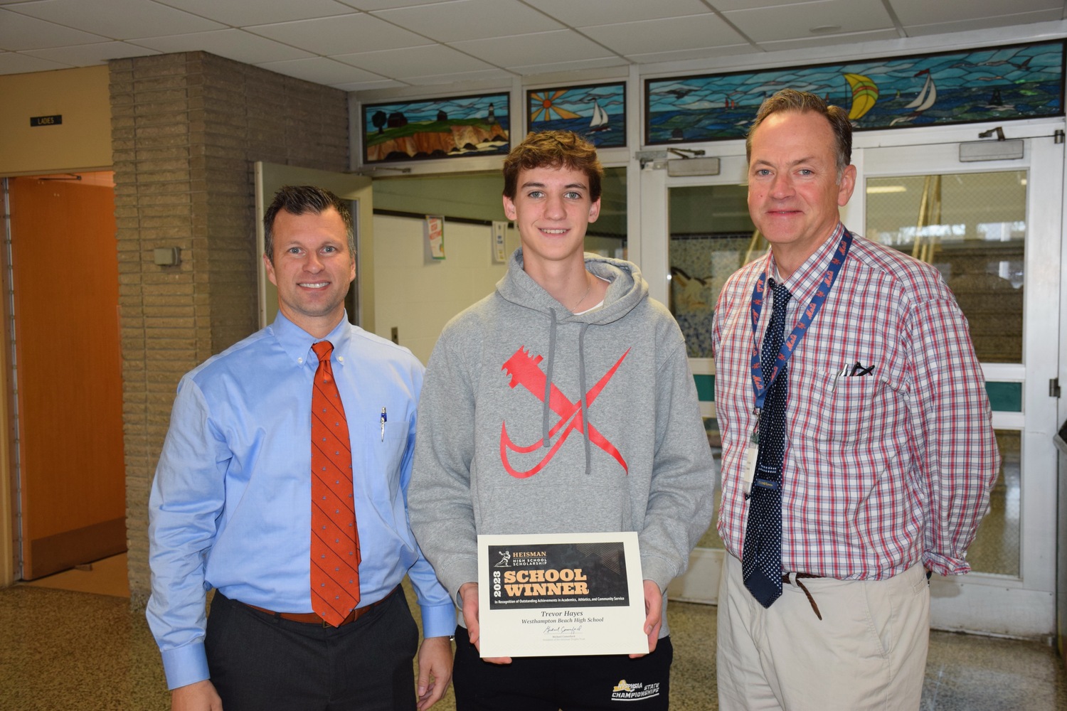 Westhampton Beach High School senior Trevor Hayes has earned a 2023 Heisman High School Scholarship award. Congratulating him are Principal Christopher Herr, left, and guidance counselor Joe Garvey. COURTESY WESTHAMPTON BEACH SCHOOL DISTRICT