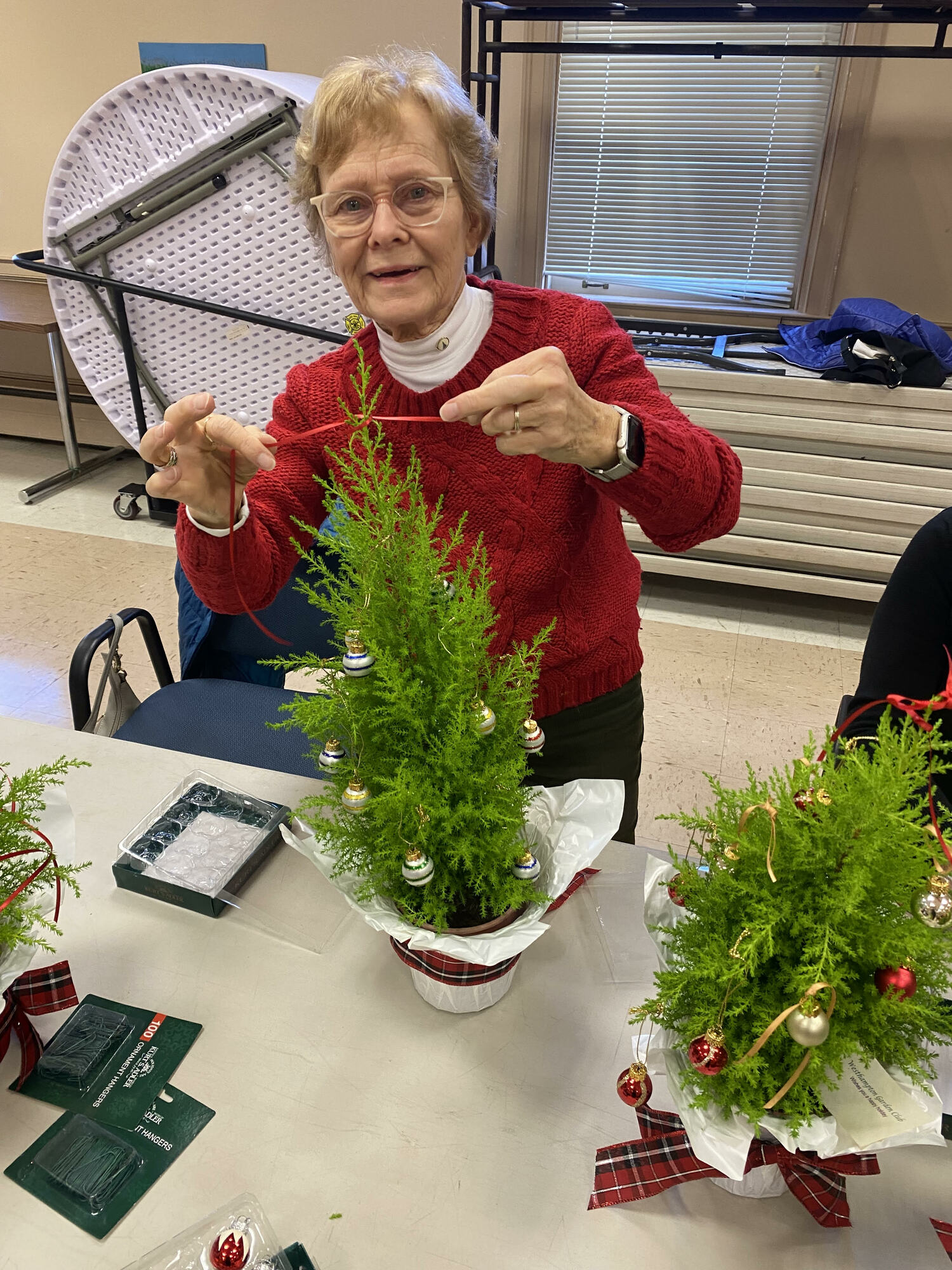 Westhampton Garden Club member r Roberta Young puts on the finishing touches on a topiary during the club's annual topiary decorating workshop. The ornamental mini-shrubs will be distributed to East End Hospice patients throughout the area and at the Kanas Center for Hospice Care in Westhampton for the holiday season. COURTESY WESTHAMPTON GARDEN CLUB