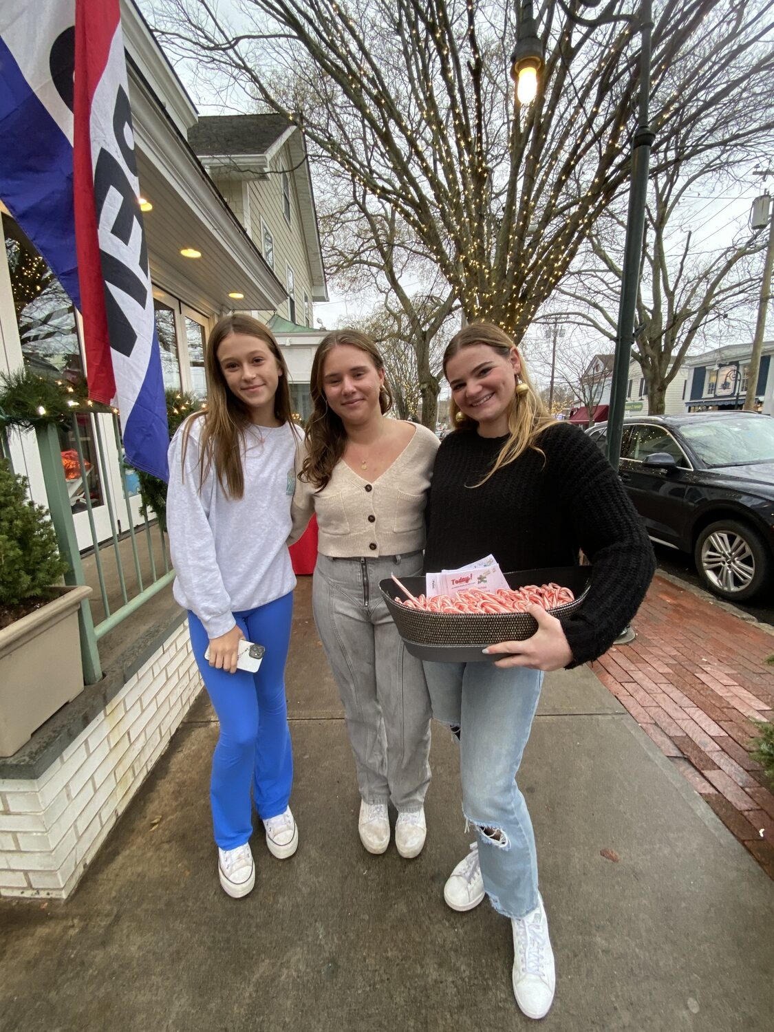 Volunteers for the Flying Point Foundation for Autism spread cheer and holiday help as it hosted a Wrap it Up for Autism event at Southampton Publick House on Sunday. During the event, the volunteers wrapped holiday gifts at no charge while raising awareness about the organization's programs.  Caitlin Zorko, Lily Perello and Caroline McGuire walked the business district to let holiday shoppers know about the opportunity to get their purchased gifts wrapped. COURTESY FLYING POINT FOUNDATION FOR AUTISM