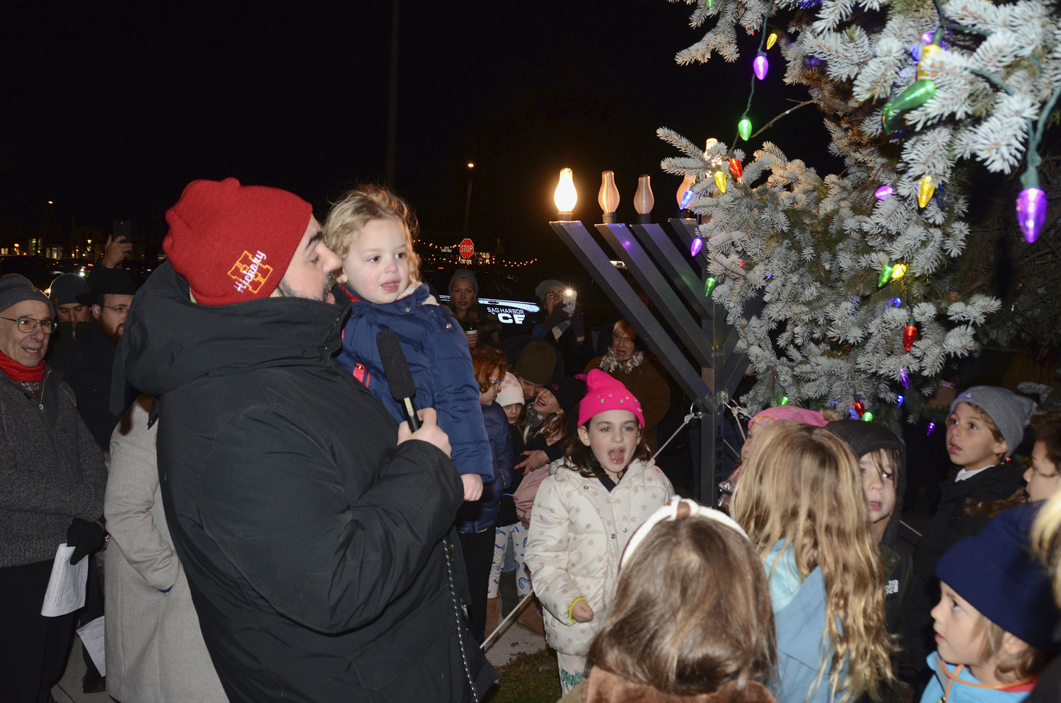 Rabbi Daniel Geffen of Temple Adas Israel lights the menorah on Long Wharf in Sag Harbor in Thursday, December 7.         KYRIL BROMLEY