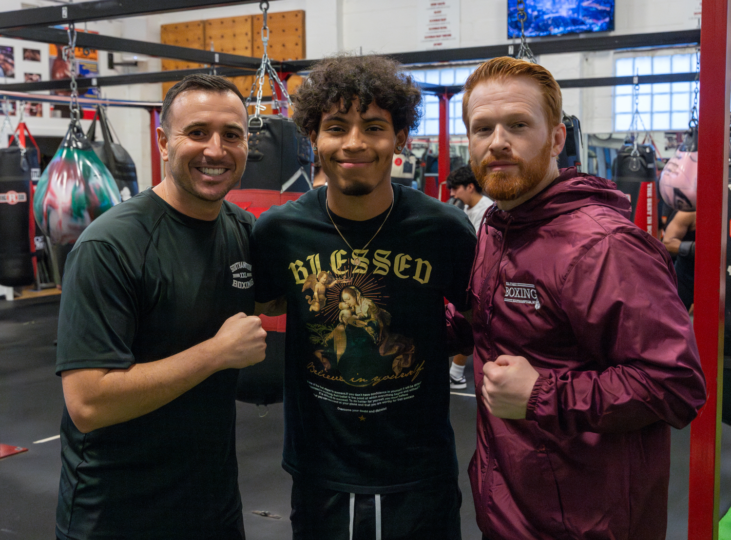 Southampton High School senior Chris Atancuri, at center, with boxing club co-adviser Chris DeRosa and Hill Street Boxing founder Avery Crocker. RON ESPOSITO