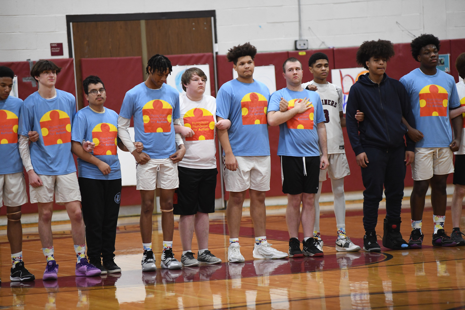 The Mariners line up with unified basketball players after player introductions. A few of the players are wearing Flying Point Foundation for Autism T-shirts as part of Autism Awareness Night where there was a unified basketball game played at halftime.   DOUG KUNTZ