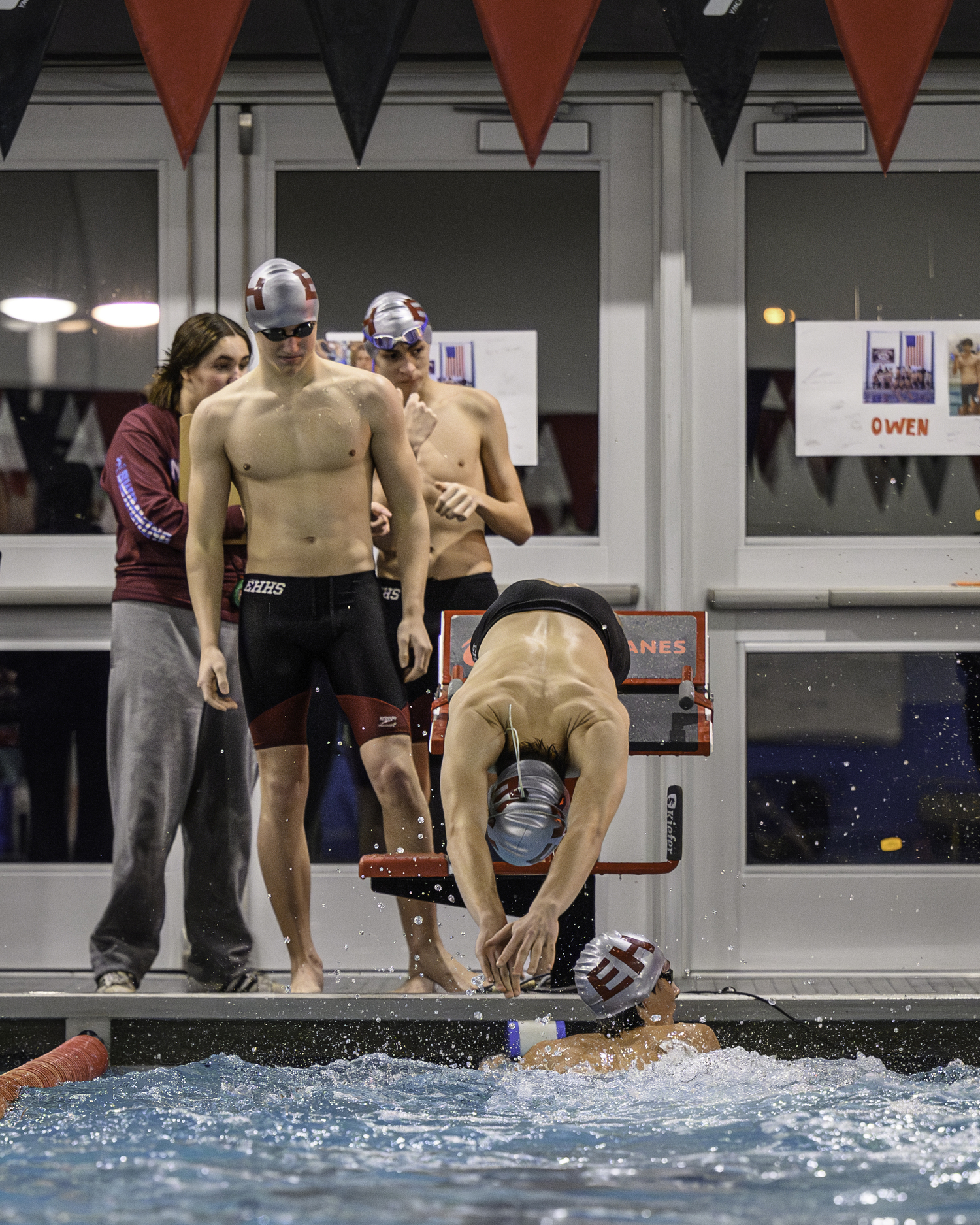 East Hampton sophomore Zeb Ryan waits his turn as senior Owen Robins jumps into the water as part o the 400-yard freestyle relay team that placed first in 4:12.14. MARIANNE BARNETT