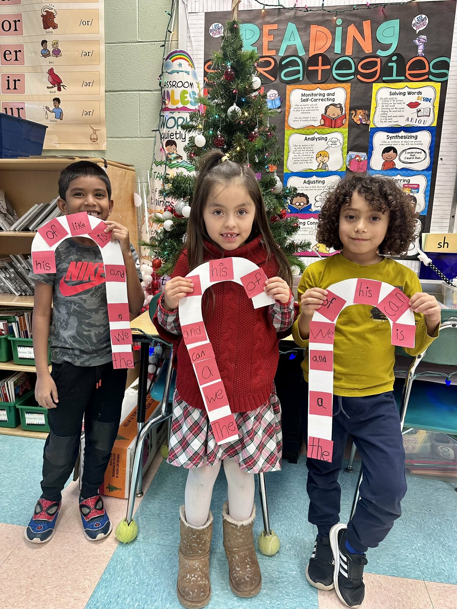 Chevel Ramjanam, Samantha Quintero Franco and Gael Valdespino were among the Hampton Bays Elementary School first grade students who  practiced their sight words through a festive holiday project. The students wrote their favorite sight words and affixed them to giant paper candy canes. COURTESY HAMPTON BAYS SCHOOL DISTRICT