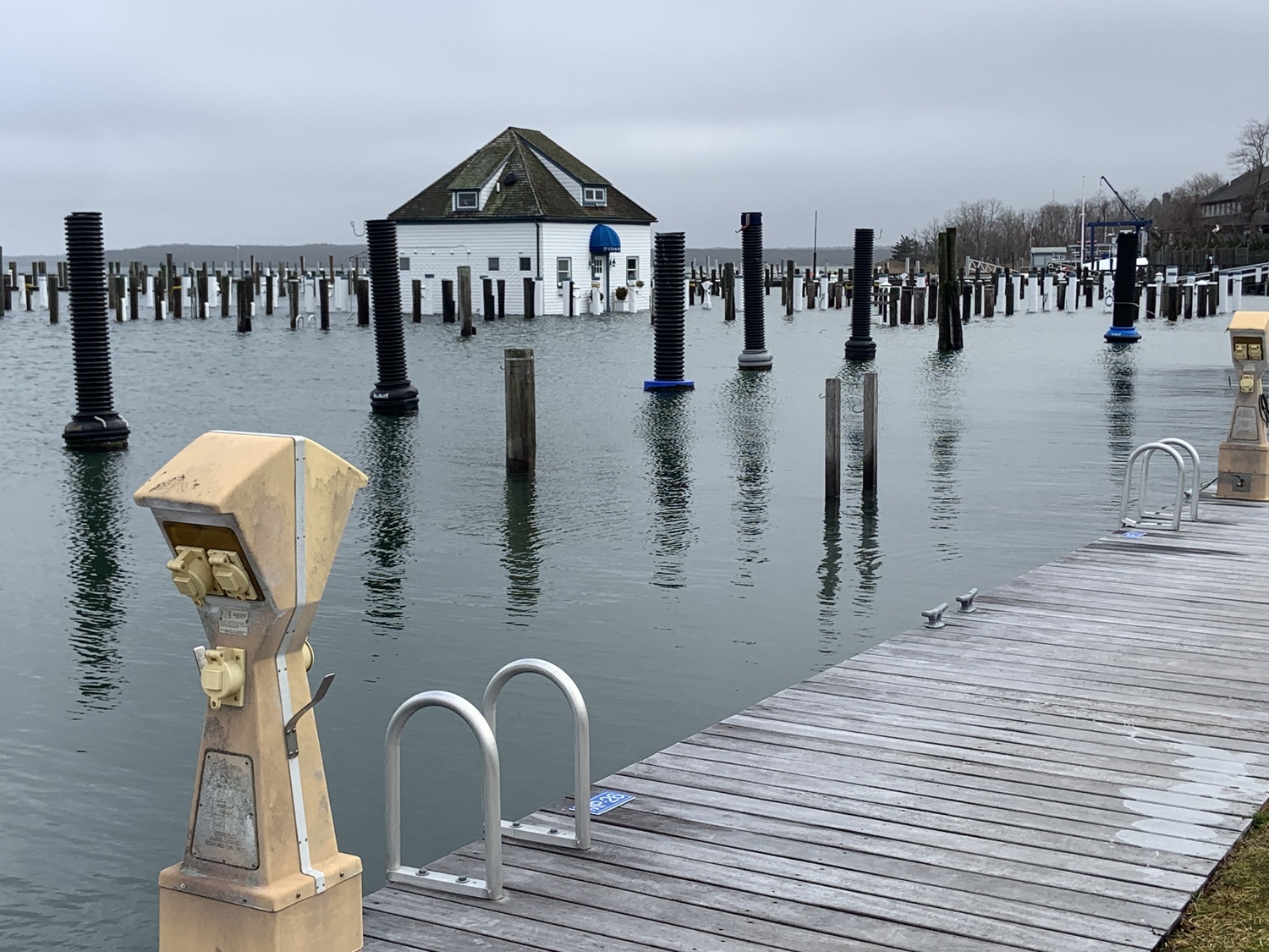 Water lapped at the base of the Sag Harbor Yacht Club at high tide on Saturday. STEPHEN J. KOTZ