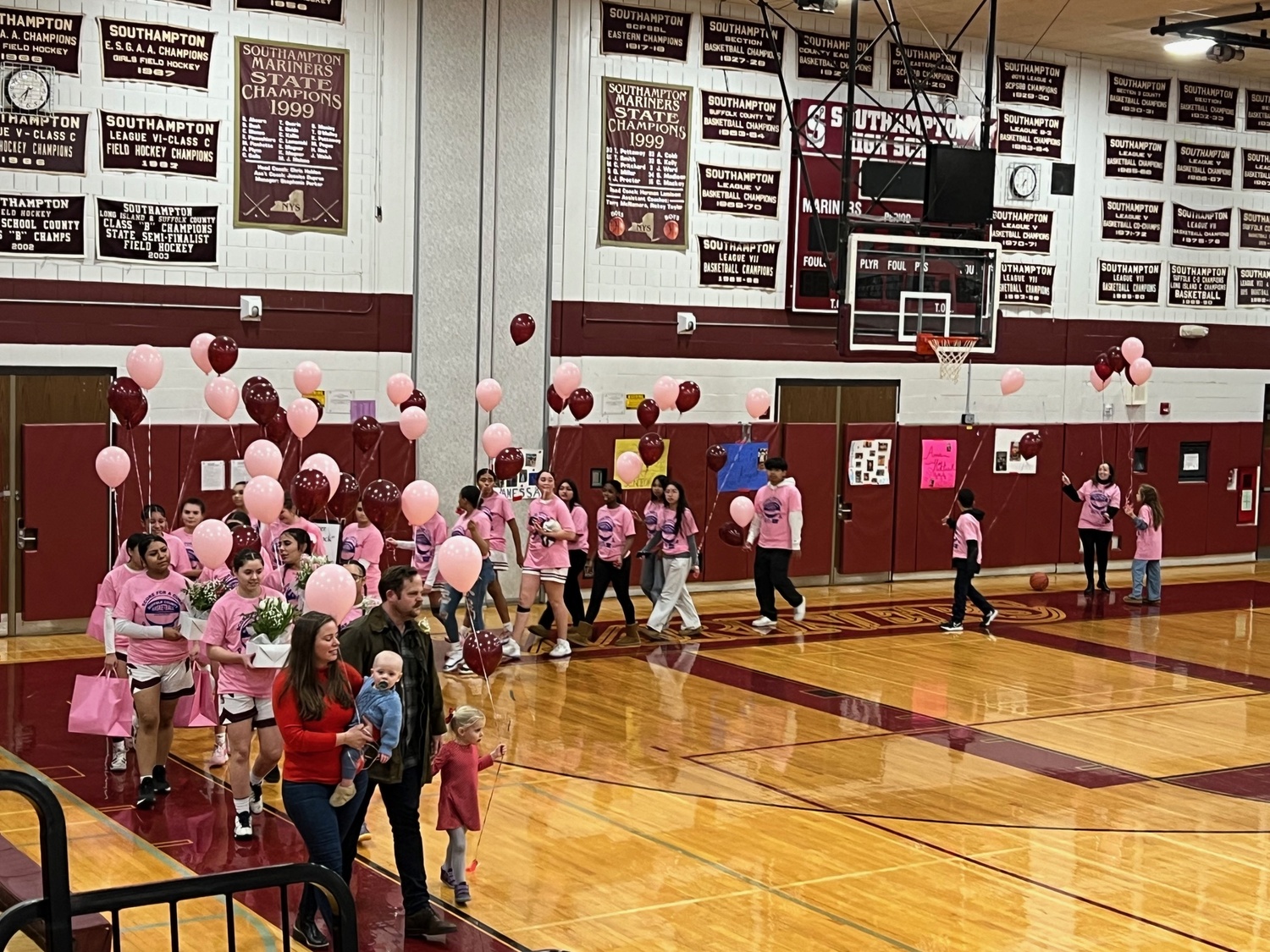 Brock Digger McMahon with his mother, Elisabeth McMahon, led the Southampton girls basketball team onto the court during their Coaches vs Cancer game on Senior Night against Center Moriches on February 14.  SARA MANNINO