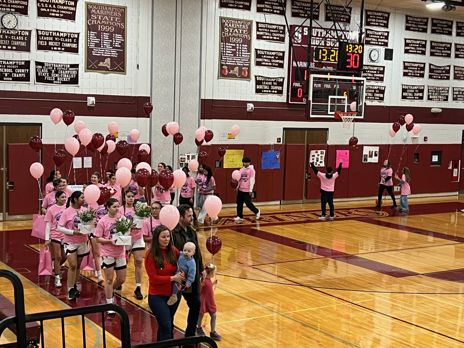 Brock Digger McMahon with his mother, Elisabeth McMahon, led the Southampton girls basketball team onto the court during their Coaches vs Cancer game on Senior Night against Center Moriches on February 14.  SARA MANNINO