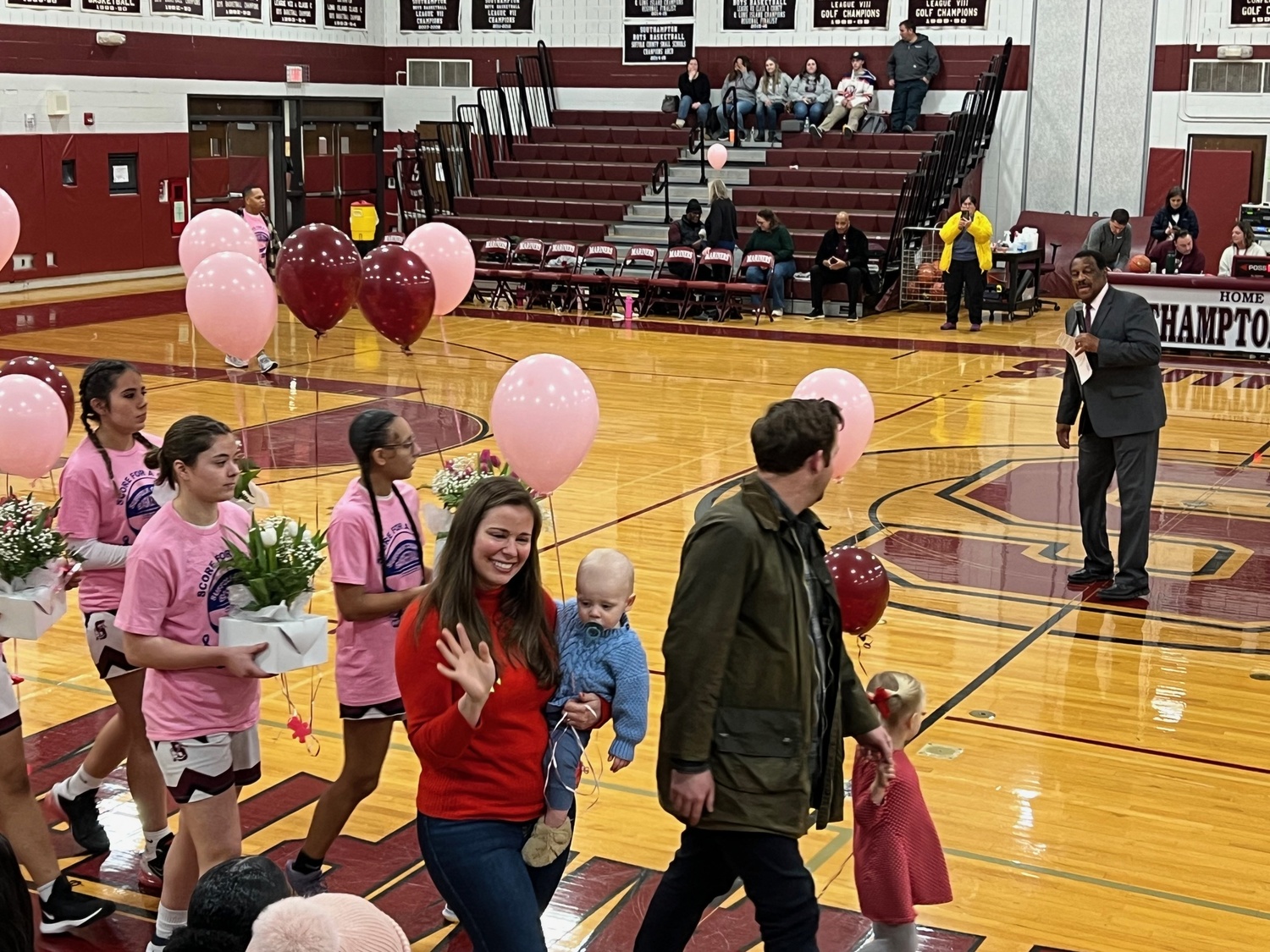 Brock Digger McMahon with his mother, Elisabeth McMahon, led the Southampton girls basketball team onto the court during their Coaches vs Cancer game on Senior Night against Center Moriches on February 14. SARA MANNINO