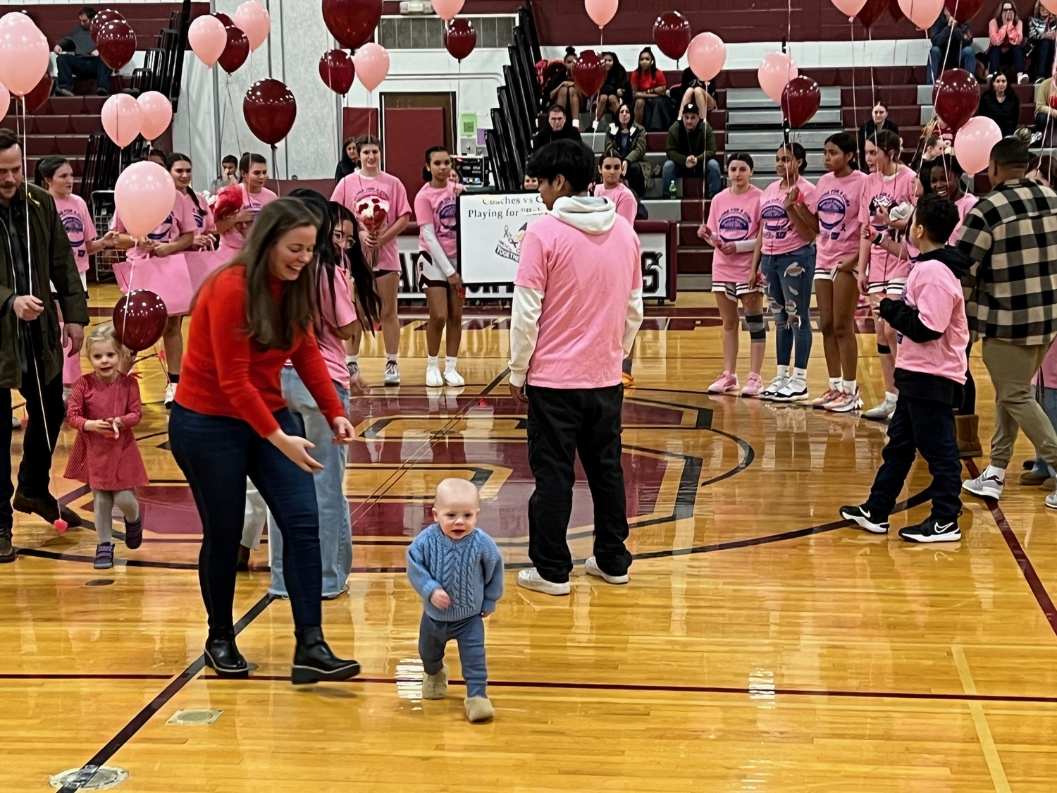 Brock Digger McMahon with his mother, Elisabeth McMahon, led the Southampton girls basketball team onto the court during their Coaches Vs Cancer game on Senior Night against Center Moriches on February 14. SARA MANNINO