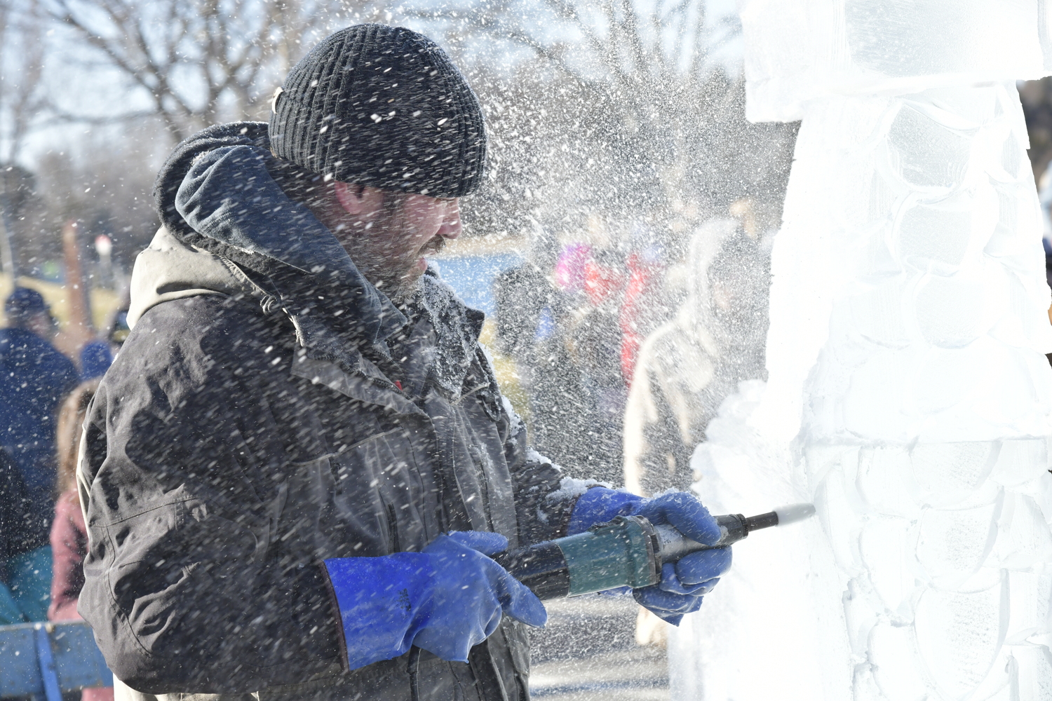 Richard Daly works on an ice sculpture on Long Wharf on Saturday.