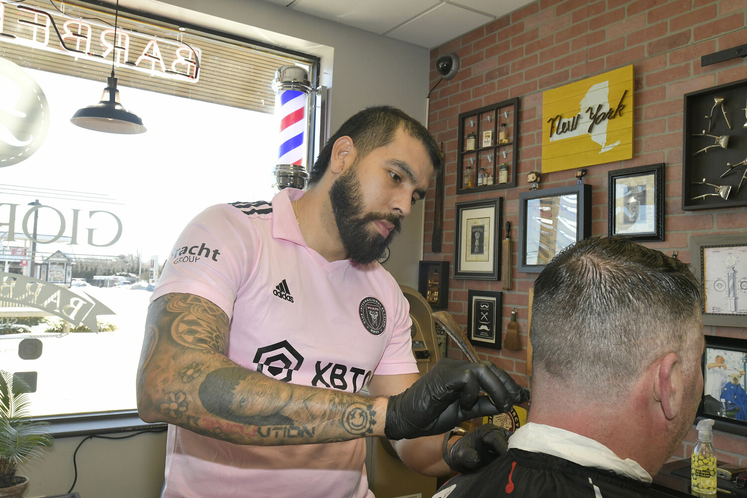 Javier Sanchez with a customer at Giorgio's Barber Shop.  DANA SHAW