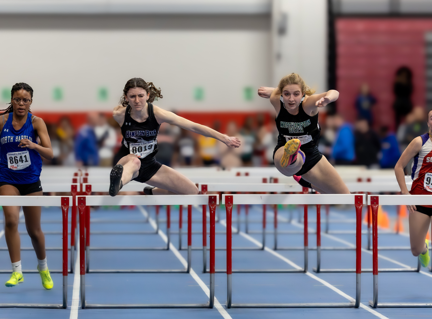 Hampton Bays senior Emma Halsey running stride for stride with Westhampton Beach senior Madison Phillips in the 55-meter hurdles. Halsey edged Phillips for fourth place and All-County honors.   RON ESPOSITO