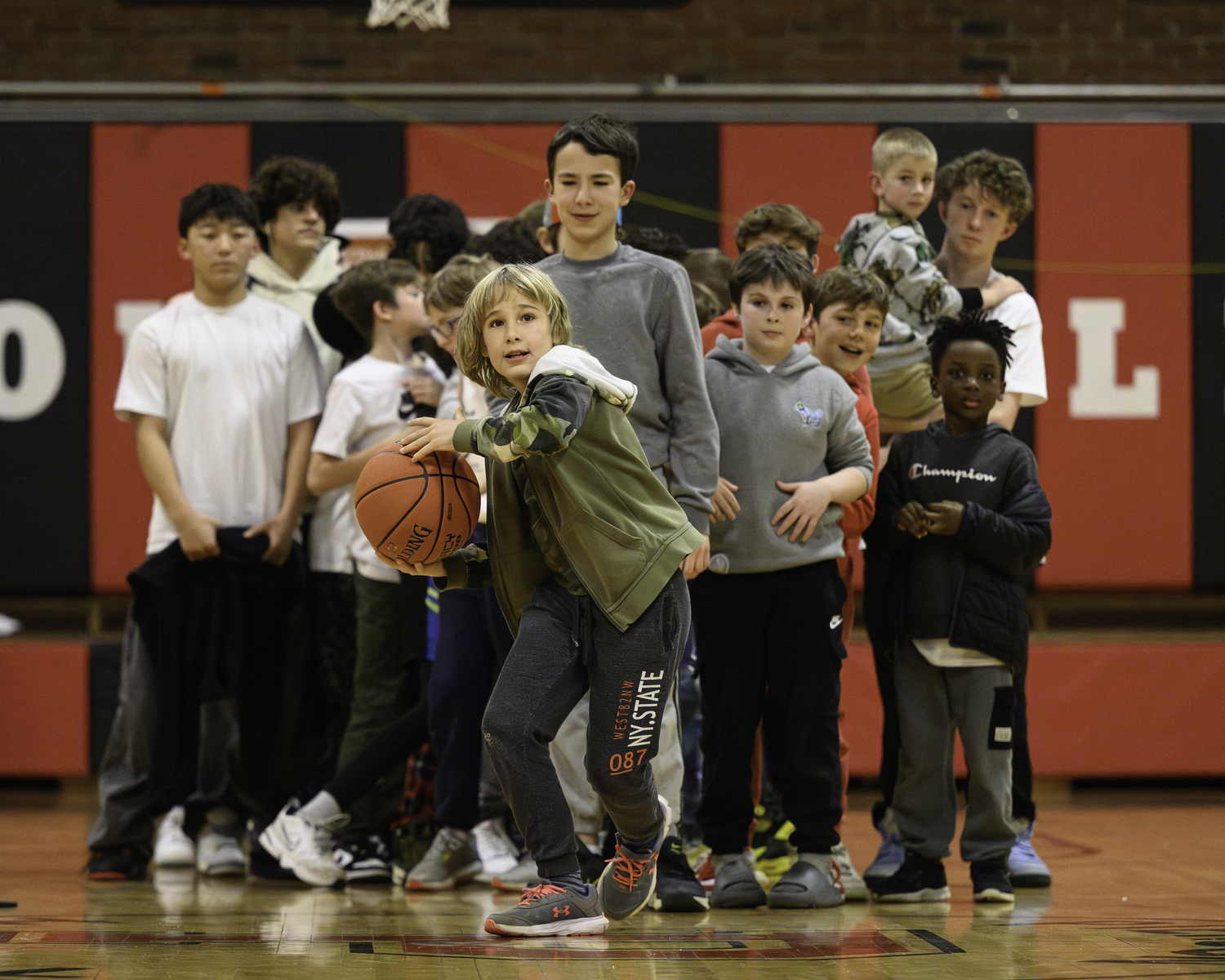 Kids line up to take their shot from halfcourt during halftime of the boy's game on Friday night.  MARIANNE BARNETT