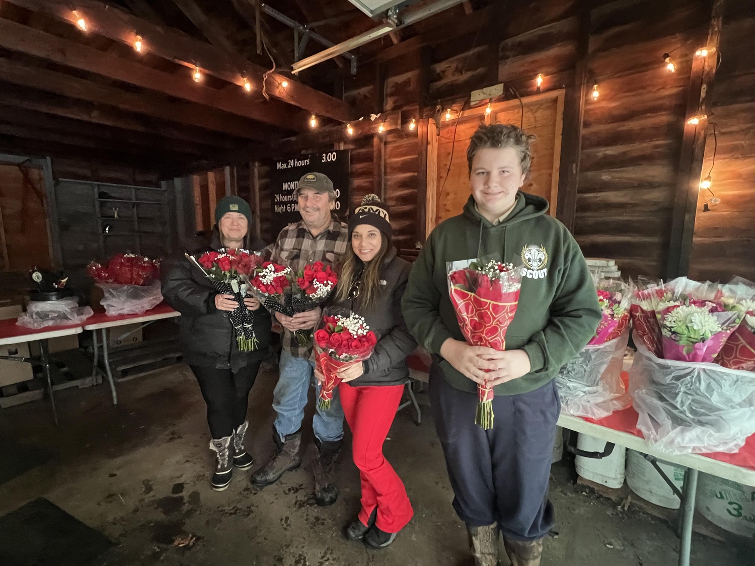 Despite the inclement weather Hampton Bays Boy Scout Troop 483 was busy selling rose bouquets  for Valentine's Day on Tuesday. Pictured are Barbara and Todd Anderson, Heather Haynia and John Anderson with some of their wares.
