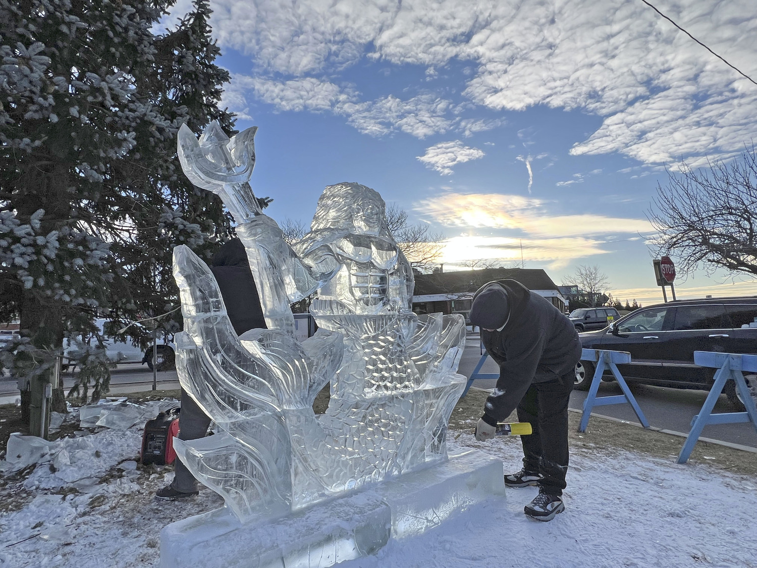 Ice carver Rich Daly works on a sculpture of Neptune on Long Wharf at HarborFrost 2023.   DANA SHAW