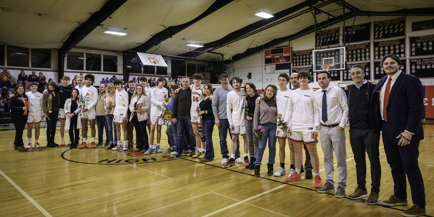 Parents of all 10 seniors, plus the varsity coaches lineup at halfcourt as part of the celebration prior to last week's game against Babylon.   MARIANNE BARNETT