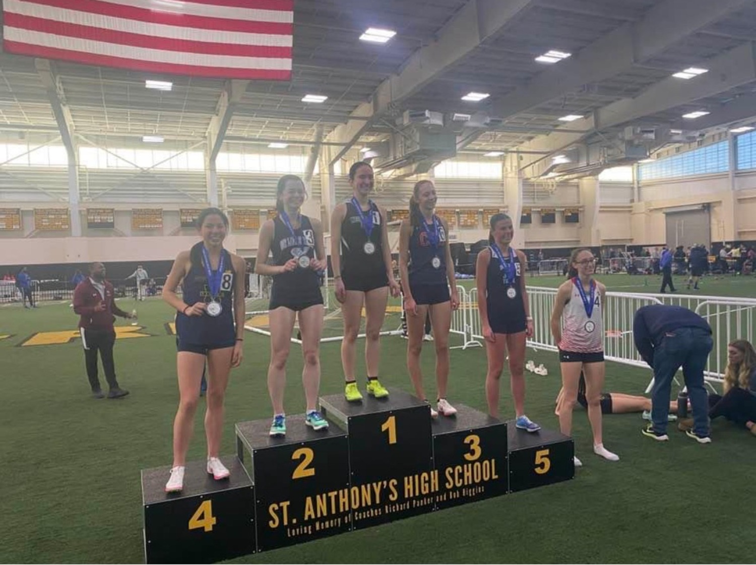 Westhampton Beach junior Lily Strebel stands atop the podium after winning the 1,000-meter race this past weekend.