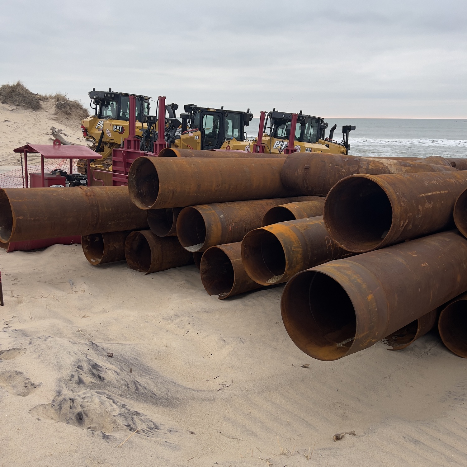Contractors working for the Army Corps of Engineers staged bulldozers and piping on the beaches in Montauk last month so that the work can commence as soon as the dredge ship Ellis Island arrives -- which could be as soon as this coming week. DOUG KUNTZ