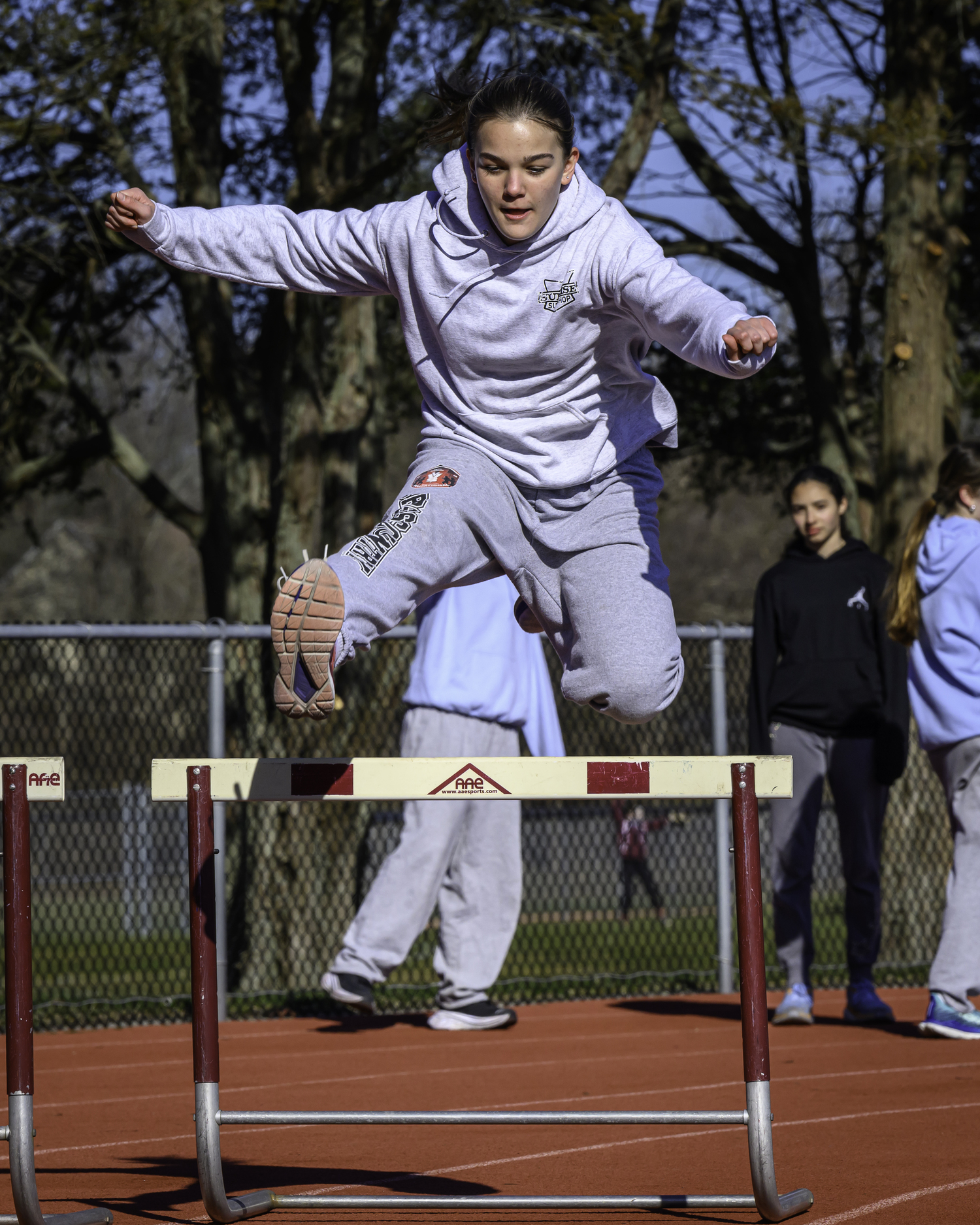 Greylynn Guyer leaps over a hurdle in practice.  MARIANNE BARNETT