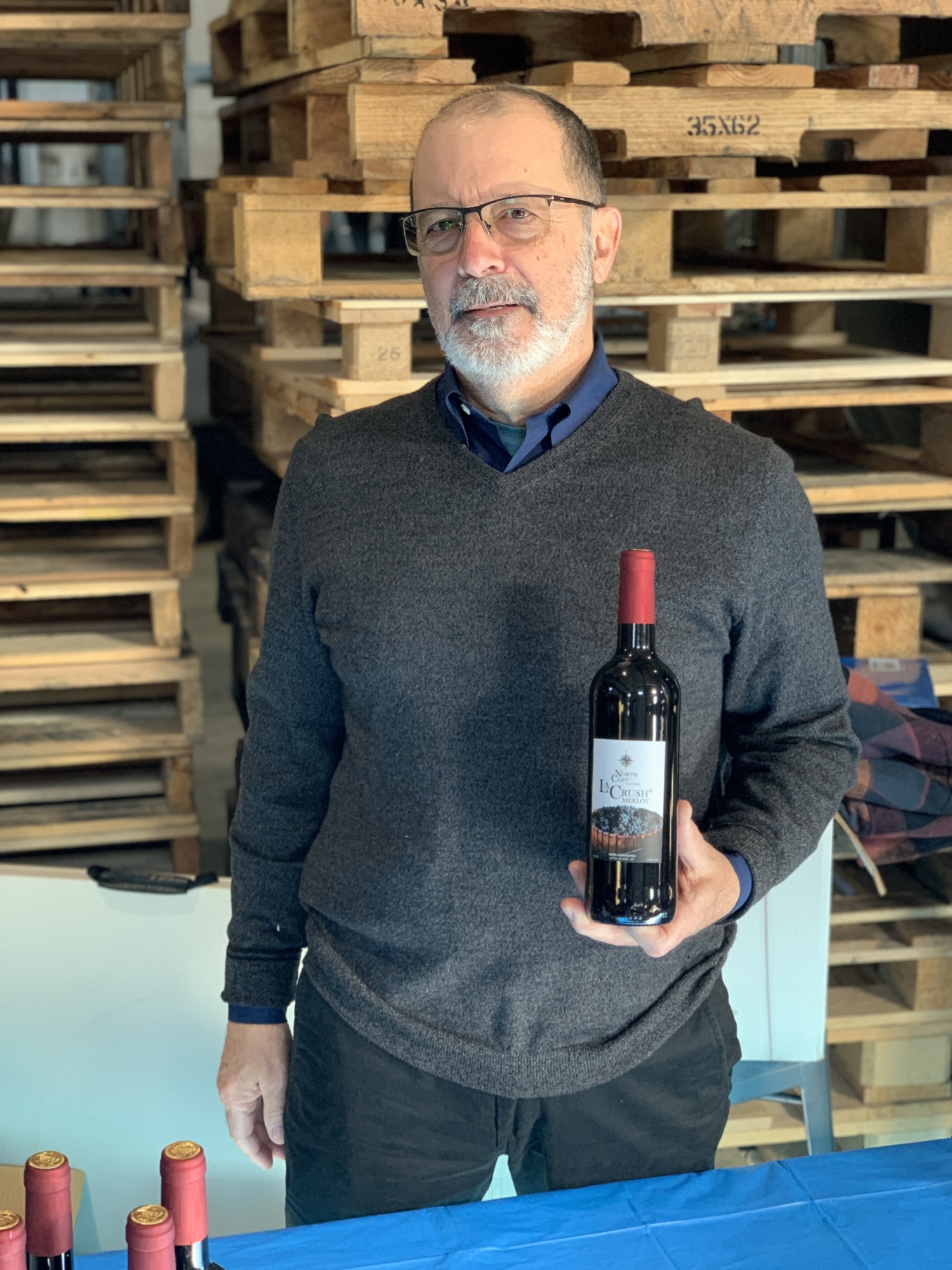 North Cliff Vineyards co-owner and winemaker Edmund Power with a bottle of his La Crush Merlot. S. DERMONT