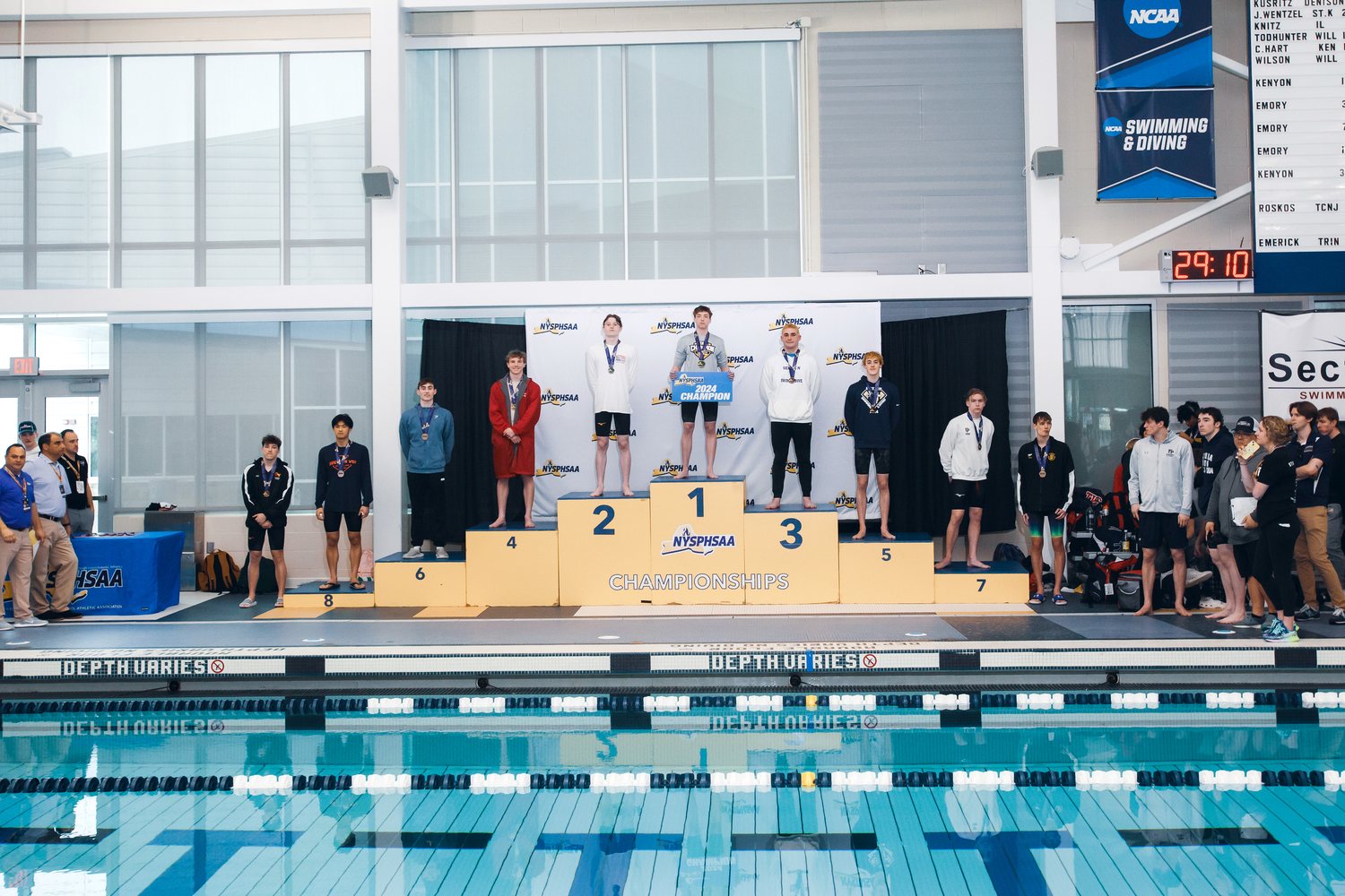 Westhampton Beach senior Max Buchen stands atop the podium after grabbing gold in the 100-yard breaststroke at the New York State Swimming and Diving Championships at Cornell University this past weekend. DAVID WILLIAMS/BEYOND THE PRINT