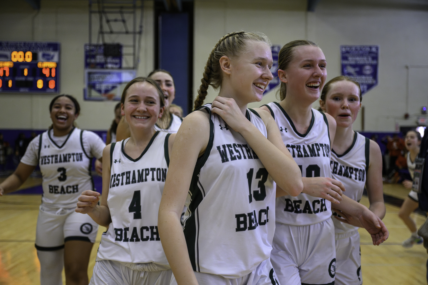 Westhampton Beach's girls basketball team members smile from ear to ear after the final buzzer. MARIANNE BARNETT