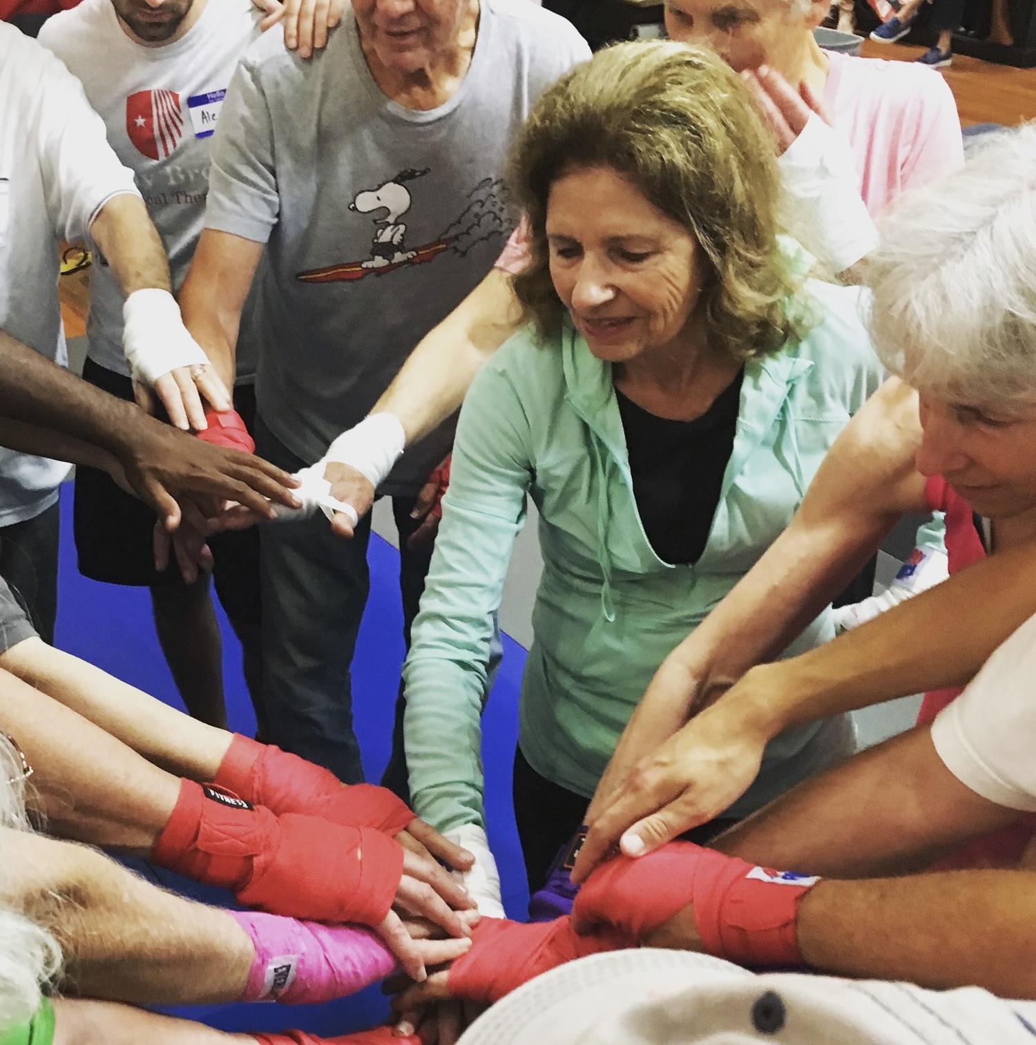 Bonnie Katz, center, puts her hands in with her fellow Rock Steady boxers at Epic Martial Arts in Sag Harbor. COURTESY MICHELLE DEL GIORNO